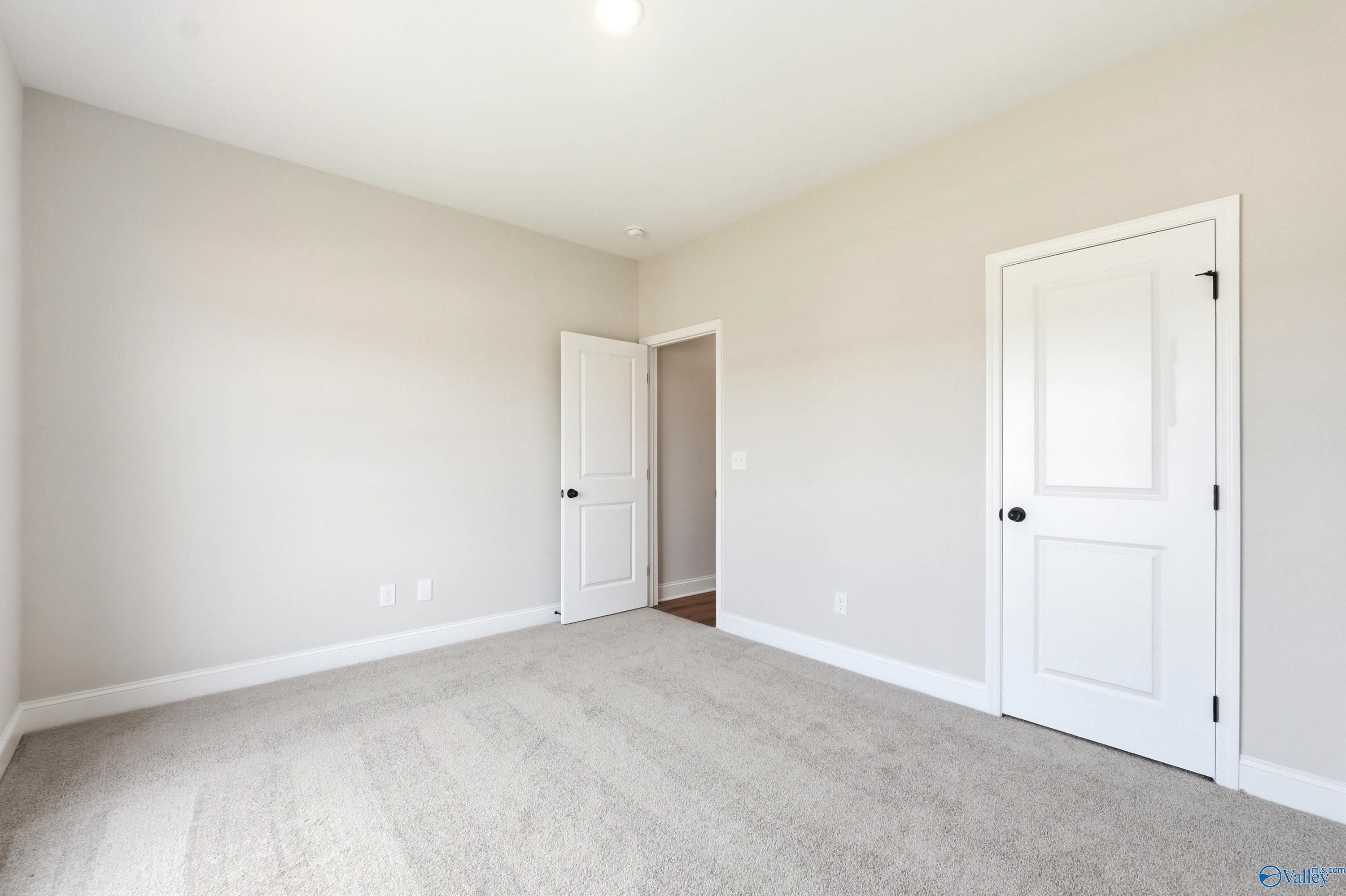 Bright, neutral-toned bedroom with plush carpet in The Daphne floor plan by Davidson Homes, Clearview, Hazel Green, AL.