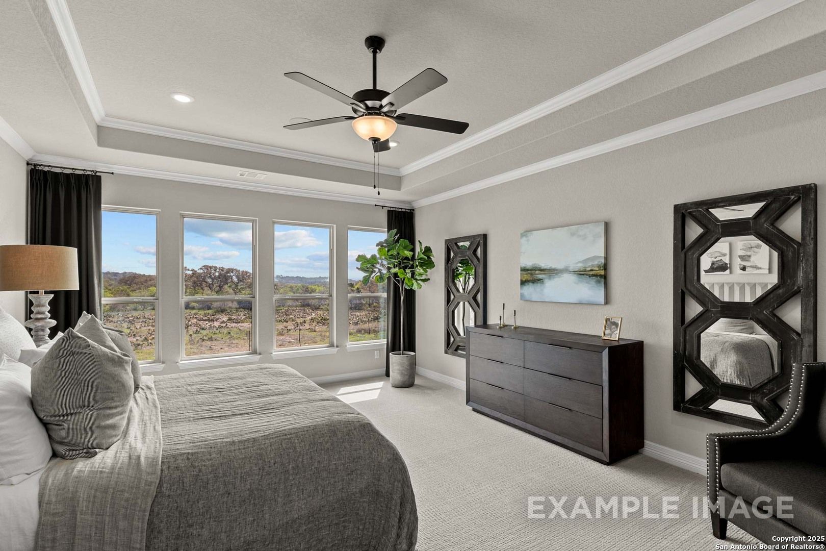 Serene master bedroom with panoramic hill views, king bed, ceiling fan, and modern dresser in Davidson Homes The Summerlin B, Castroville, TX