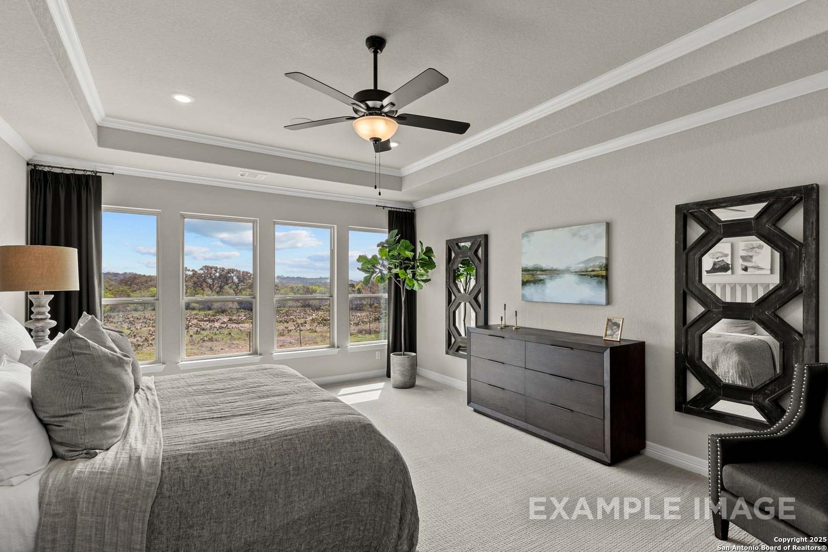 Serene master bedroom with panoramic hill views, king bed, ceiling fan, and modern dresser in Davidson Homes The Summerlin B, Castroville, TX