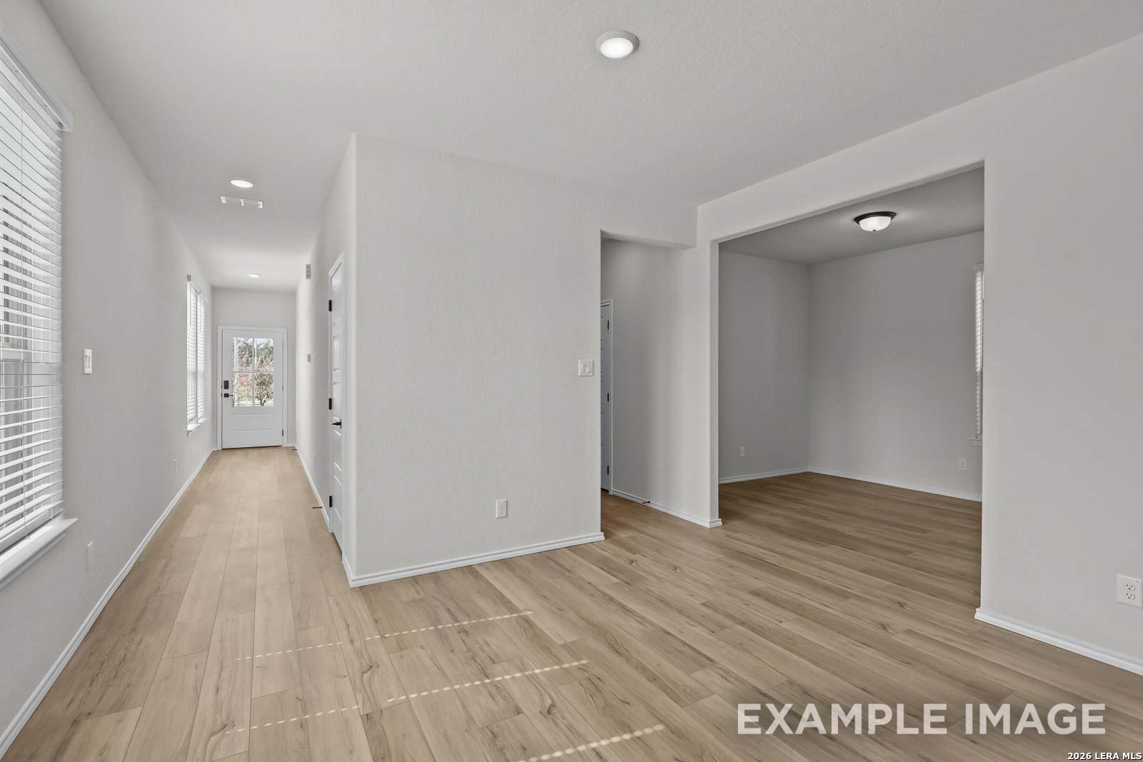 Bright entryway and flexible living space with wood-look flooring in The Florence D floor plan by Davidson Homes.