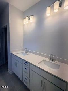 Modern bathroom with double vanity, quartz countertops, and dual light fixtures in The Daphne D home at Woodland Crossing.