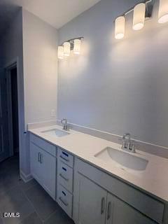 Modern bathroom with double vanity, quartz countertops, and dual light fixtures in The Daphne D home at Woodland Crossing.