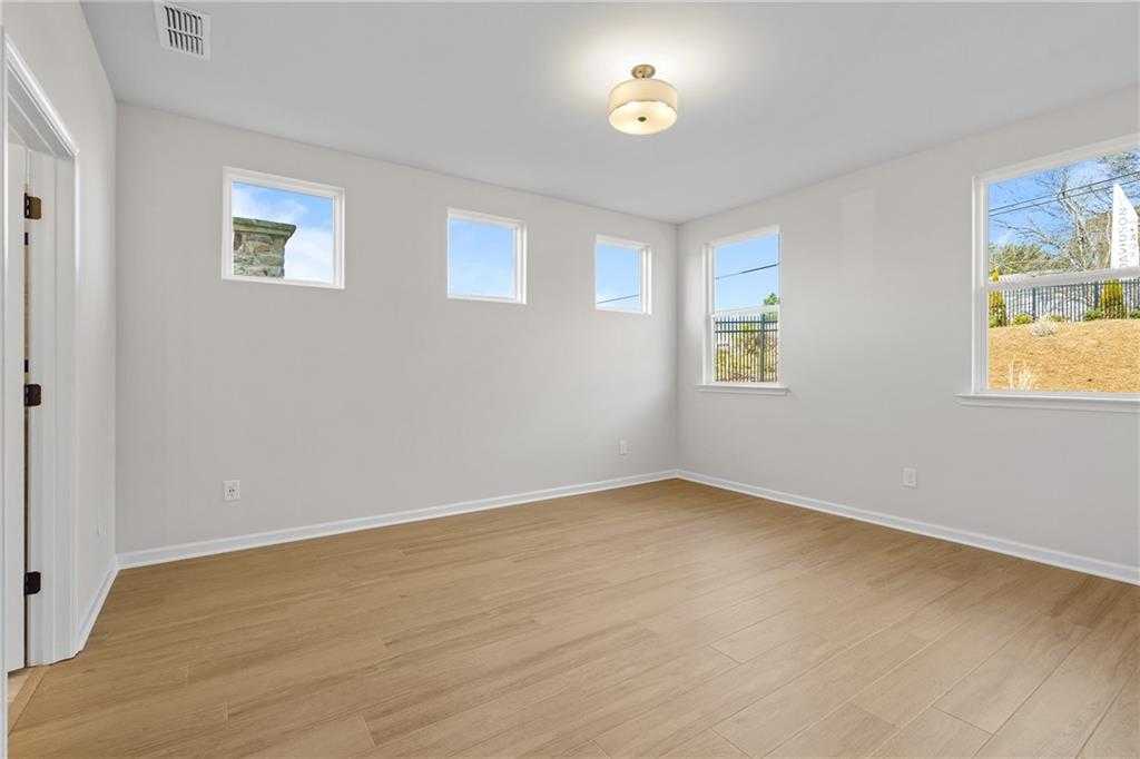 Bright bedroom with large windows overlooking backyard, hardwood floors in The Edison A, Davidson Homes, Loganville, GA