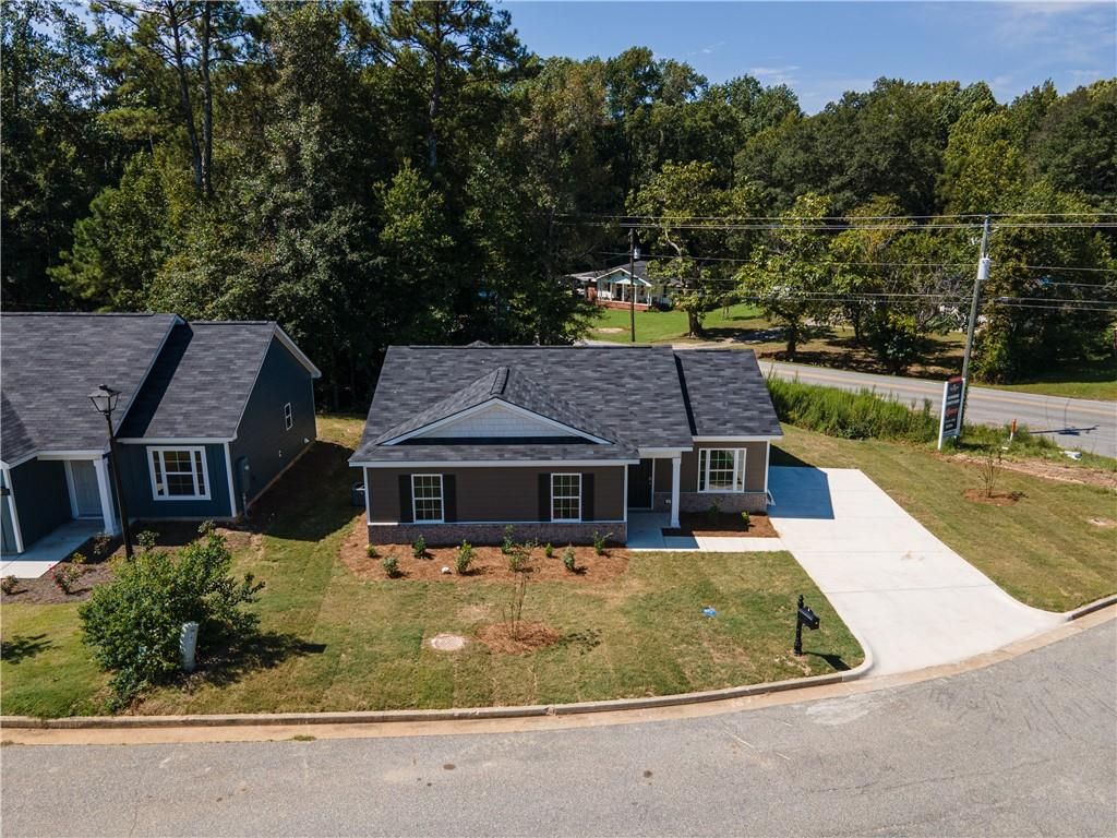 Modern 1-story gray home with driveway, shrubs, and trees in Summer Vineyard, Phenix City, Alabama by Davidson Homes