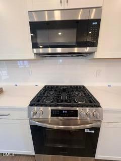 Modern kitchen with stainless steel gas range and microwave in The Willow B floor plan at Woodland Crossing, Zebulon, NC.