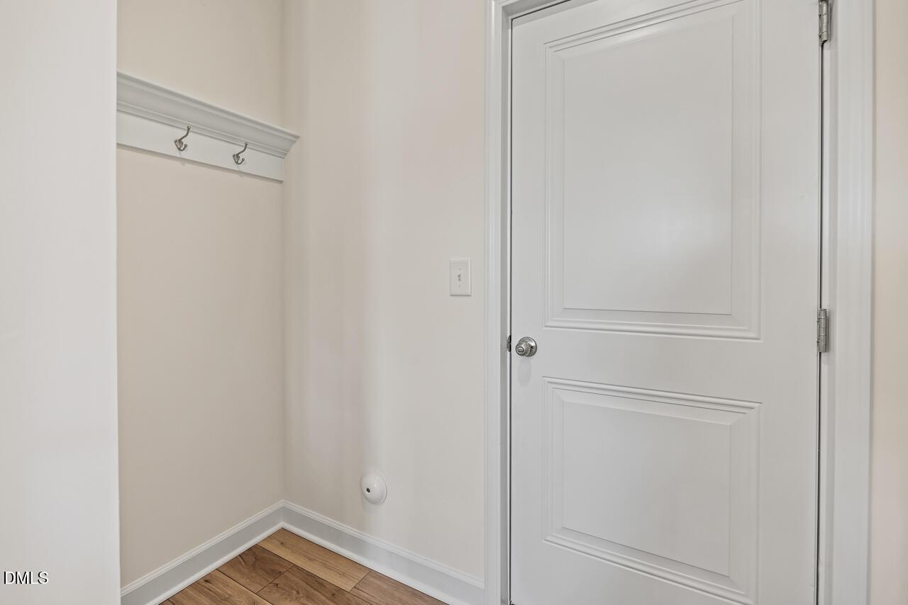 Mudroom entry with coat hooks and white panel door in Davidson Homes The Hickory II B, Retreat at North Main, Lillington, NC