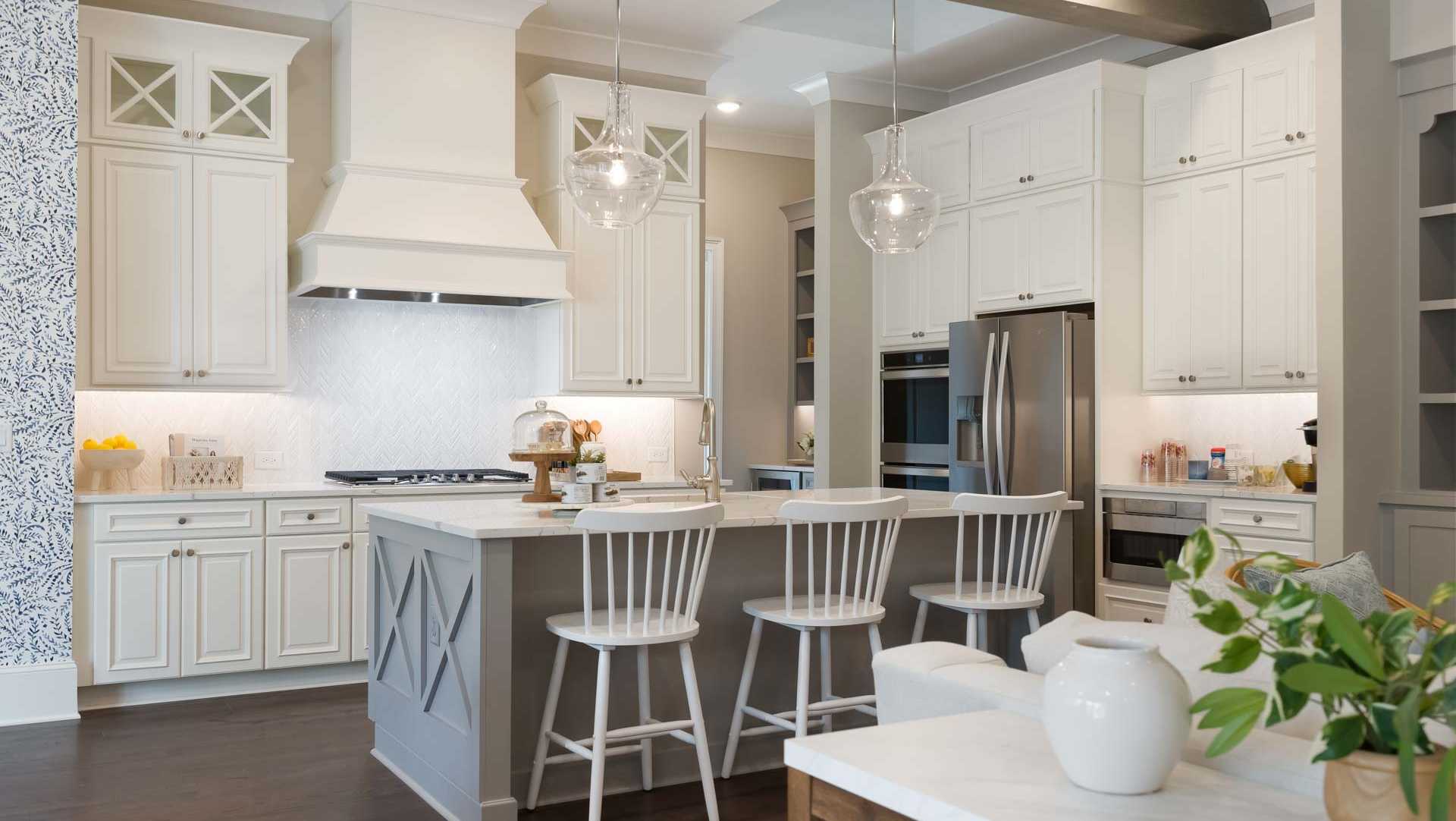 Spacious Davidson Homes kitchen featuring white shaker cabinets, gray shiplap island with bar stools, stainless appliances, and subway tile backsplash