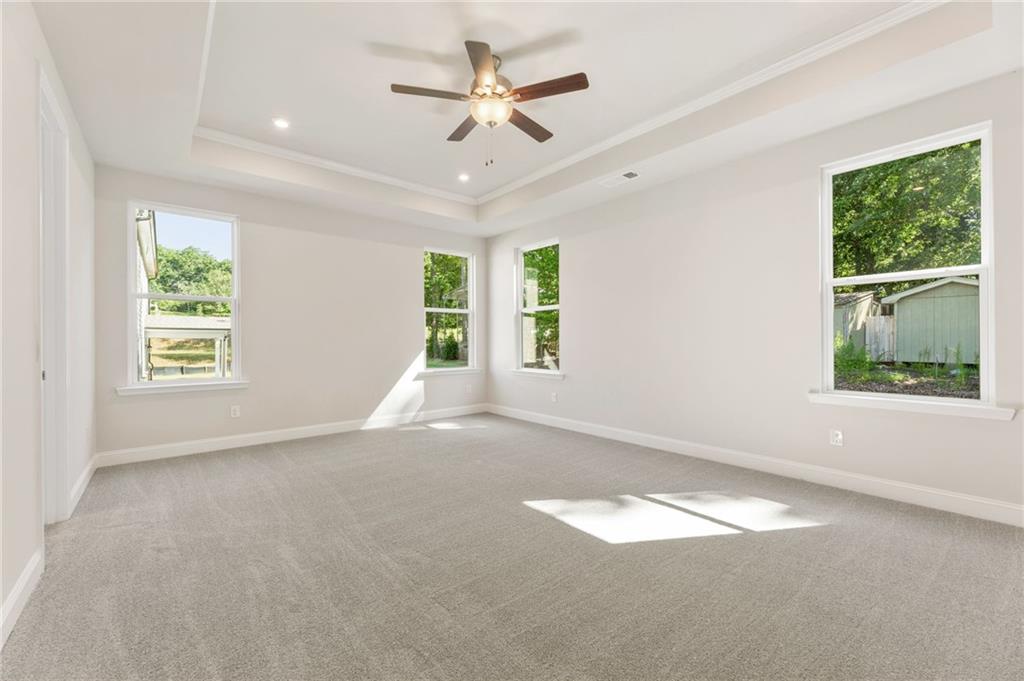 Bright bedroom with large windows, natural light, and backyard view in 5-bedroom Davidson Homes The Danbury E, Buford, Georgia