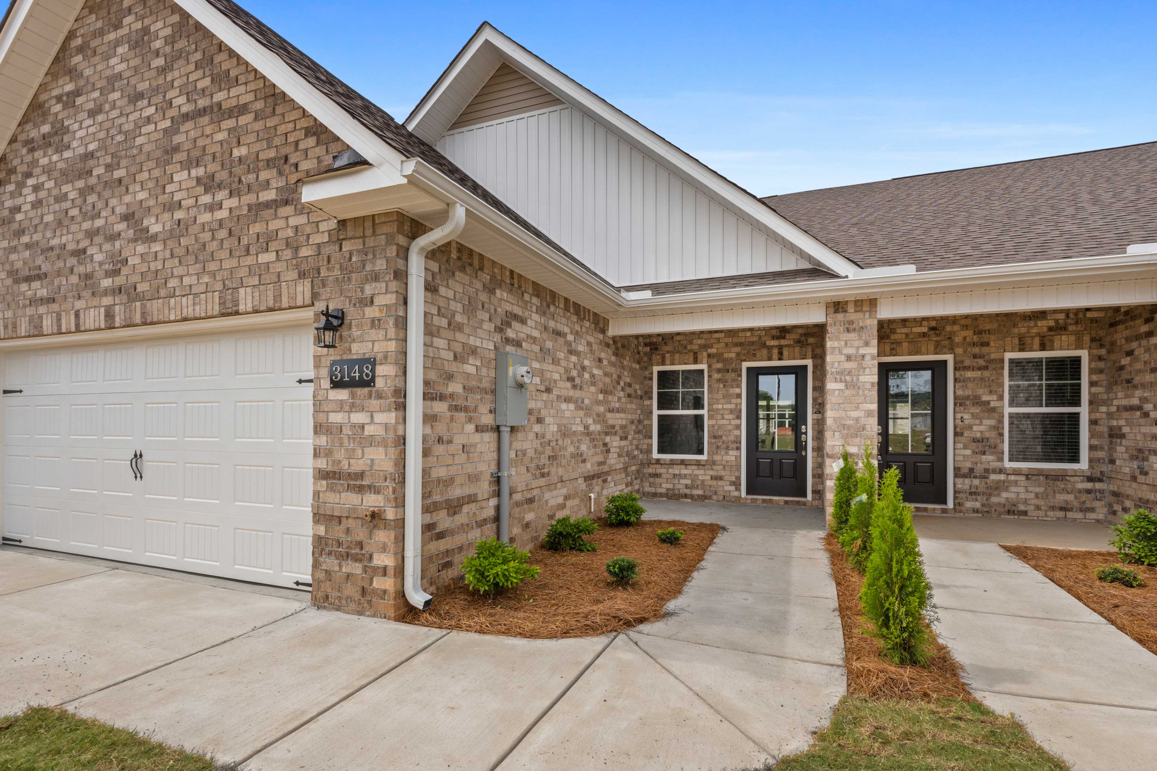 Brick home exterior at The Retreat at Hollon Meadow in Decatur Alabama with attached garage covered porch and landscaped entry