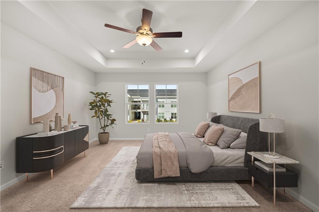 Primary bedroom with tray ceiling and modern decor in The Monroe B floor plan at Stegall Village, Emerson, Georgia.