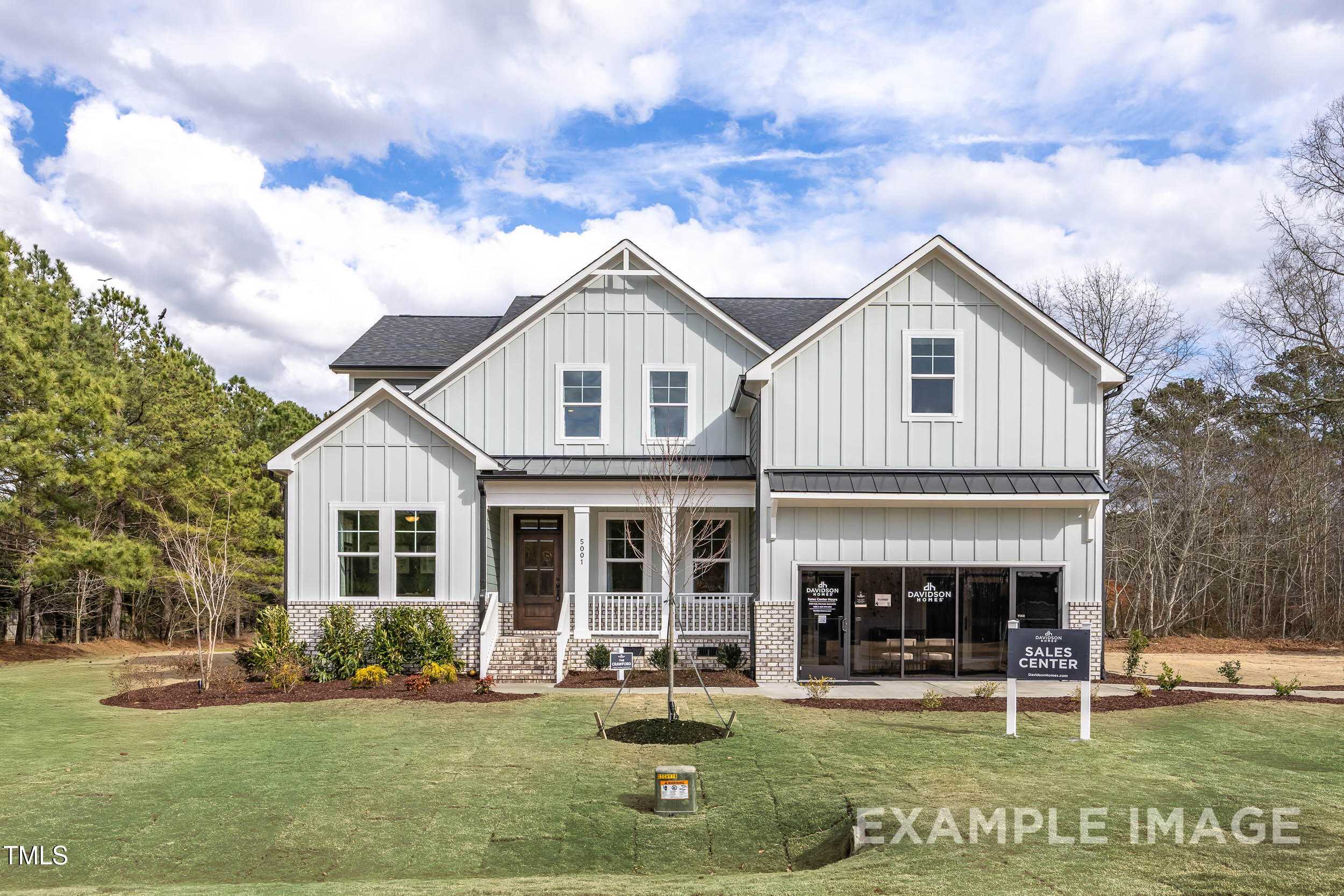 Modern two-story Crawford C home with white shake siding, front porch, garage, and sales sign in Laneridge Estates, Raleigh, NC