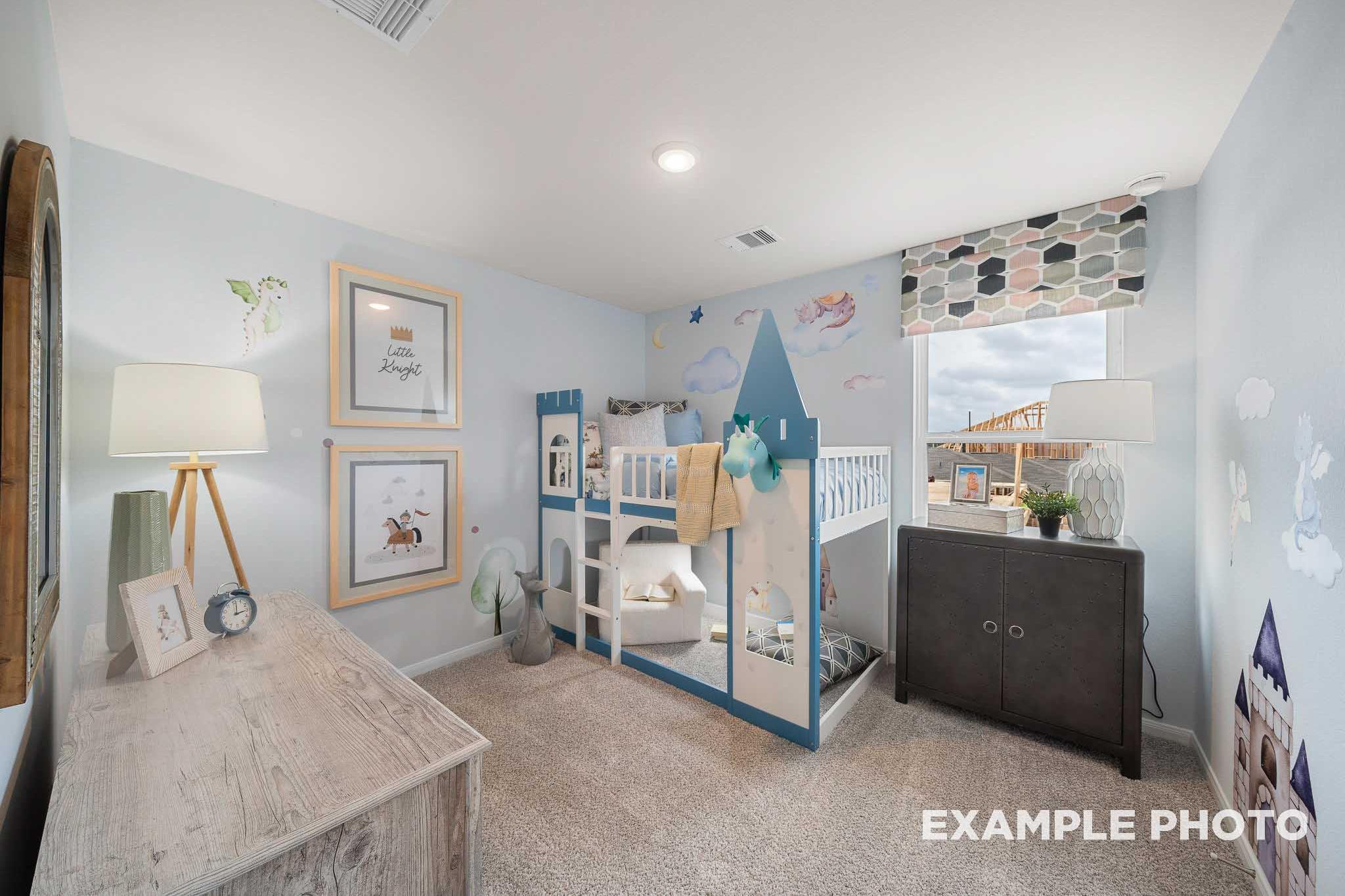 Charming light blue children's bedroom in The Trinity featuring castle bunk bed, framed art, and playful decor