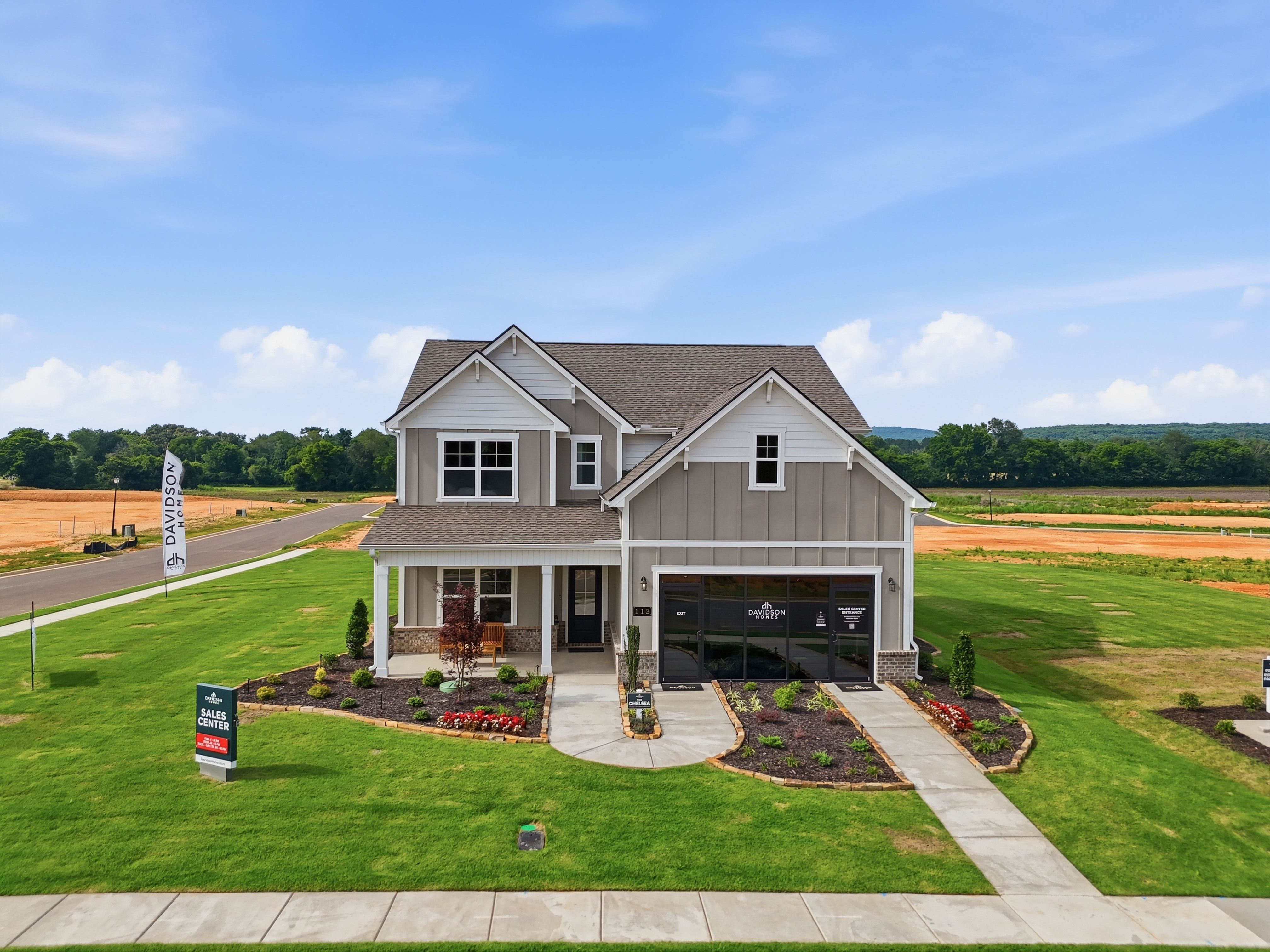 Davidson Homes sales center model home at Berry Cove in New Market, Alabama with a front porch and landscaped yard.