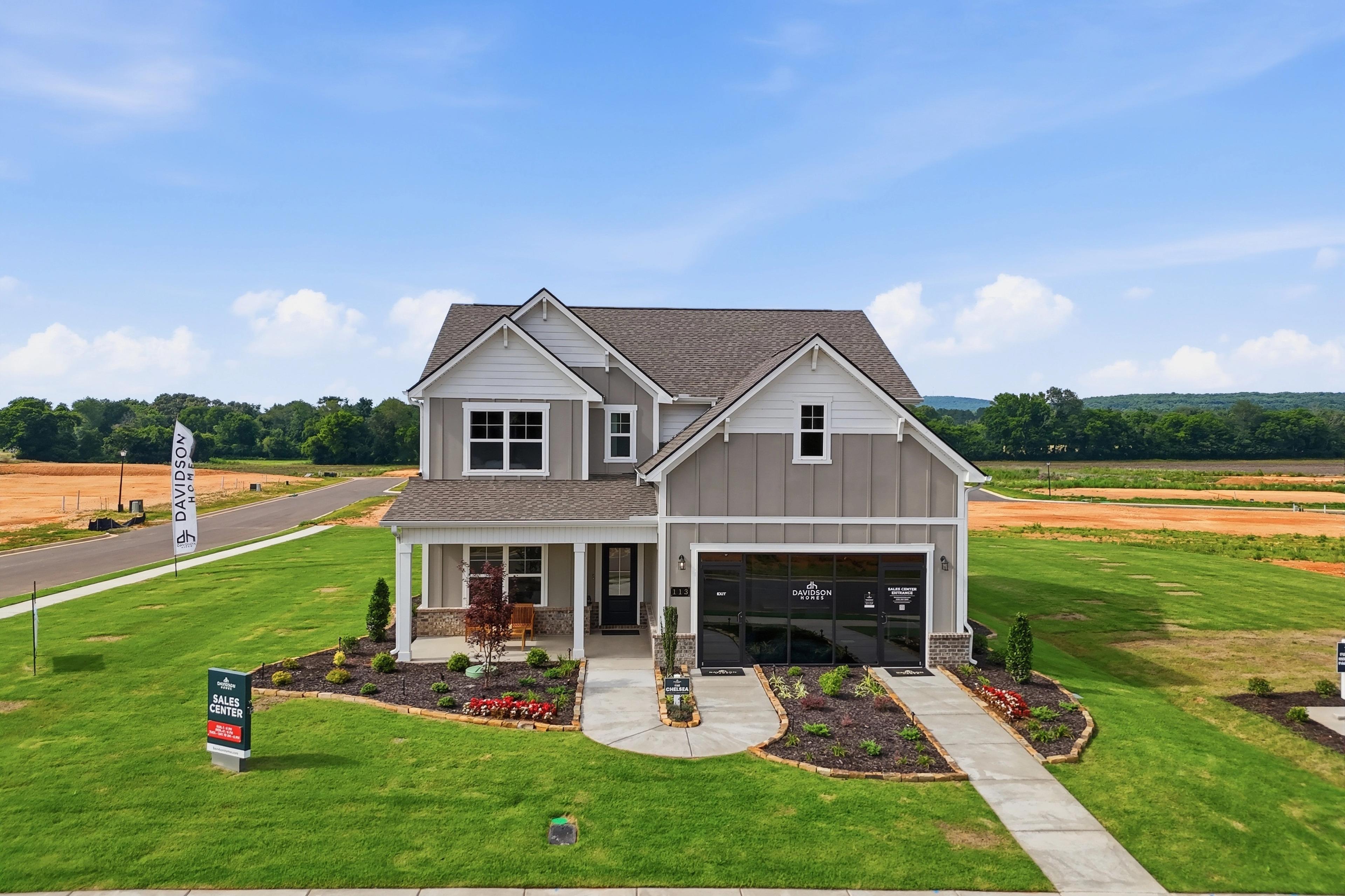 Davidson Homes sales center model home at Berry Cove in New Market, Alabama with a front porch and landscaped yard.