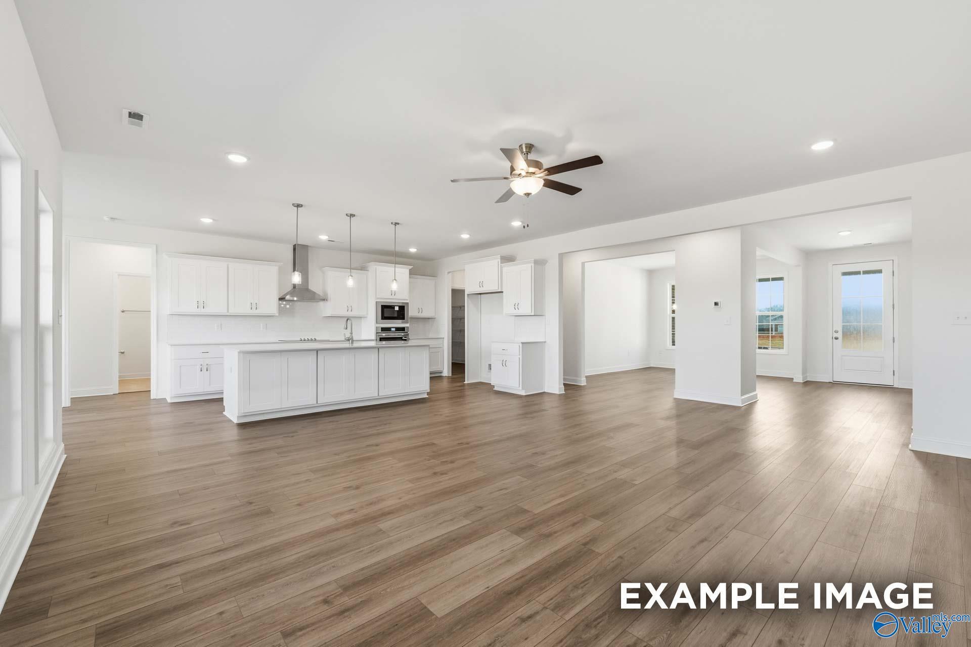 Open-concept kitchen and living area with white cabinets in The Valencia floor plan by Davidson Homes in Briercreek.