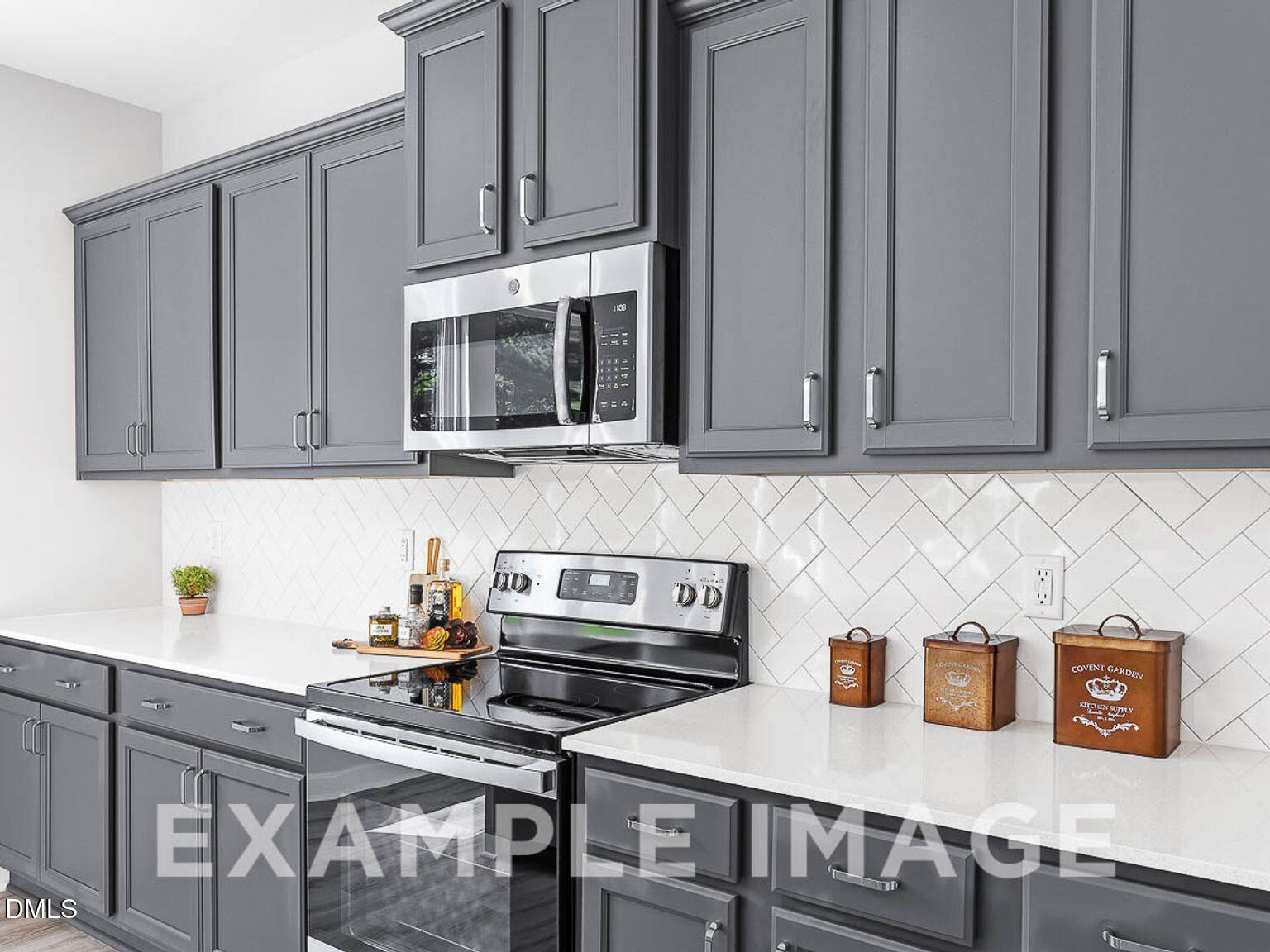 Modern gray shaker kitchen cabinets, stainless steel appliances, white subway tile backsplash in The Chestnut B, Lillington, NC