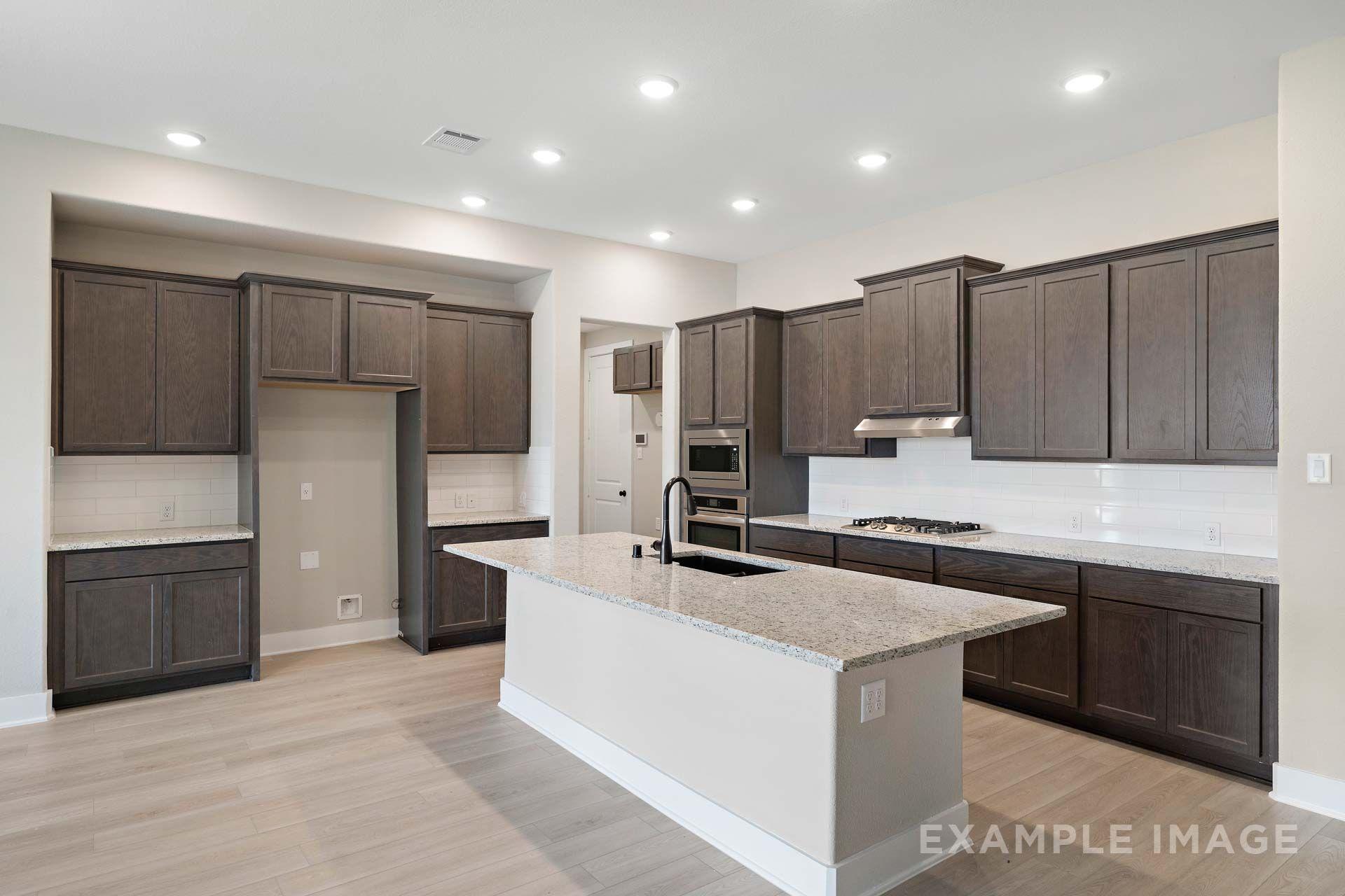 Gourmet kitchen in The Elizabeth by Davidson Homes featuring granite island, dark cabinetry, and subway tile backsplash