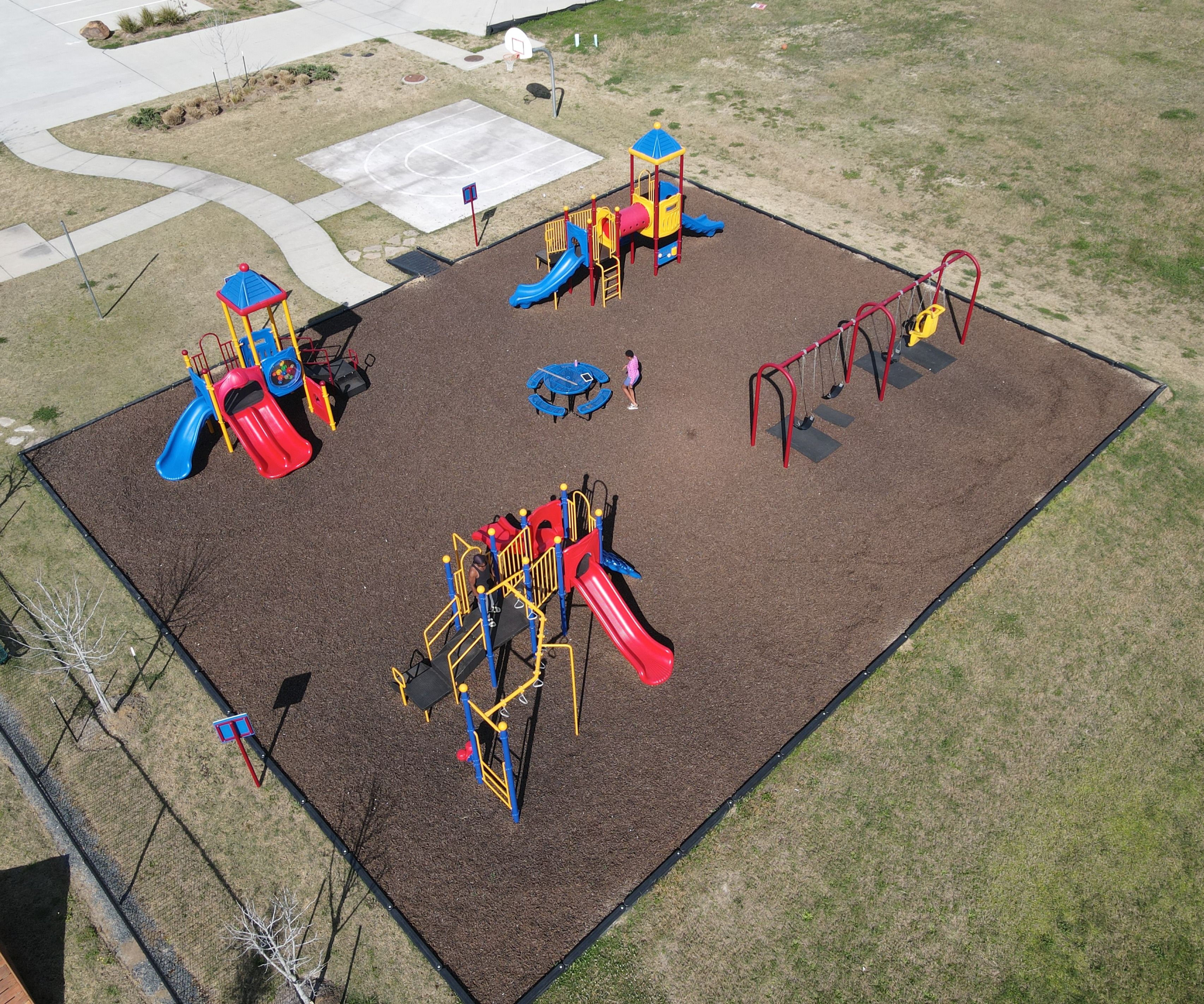 Colorful playground with slides, swings and play towers at The Villages at WestPointe in Dayton, Texas