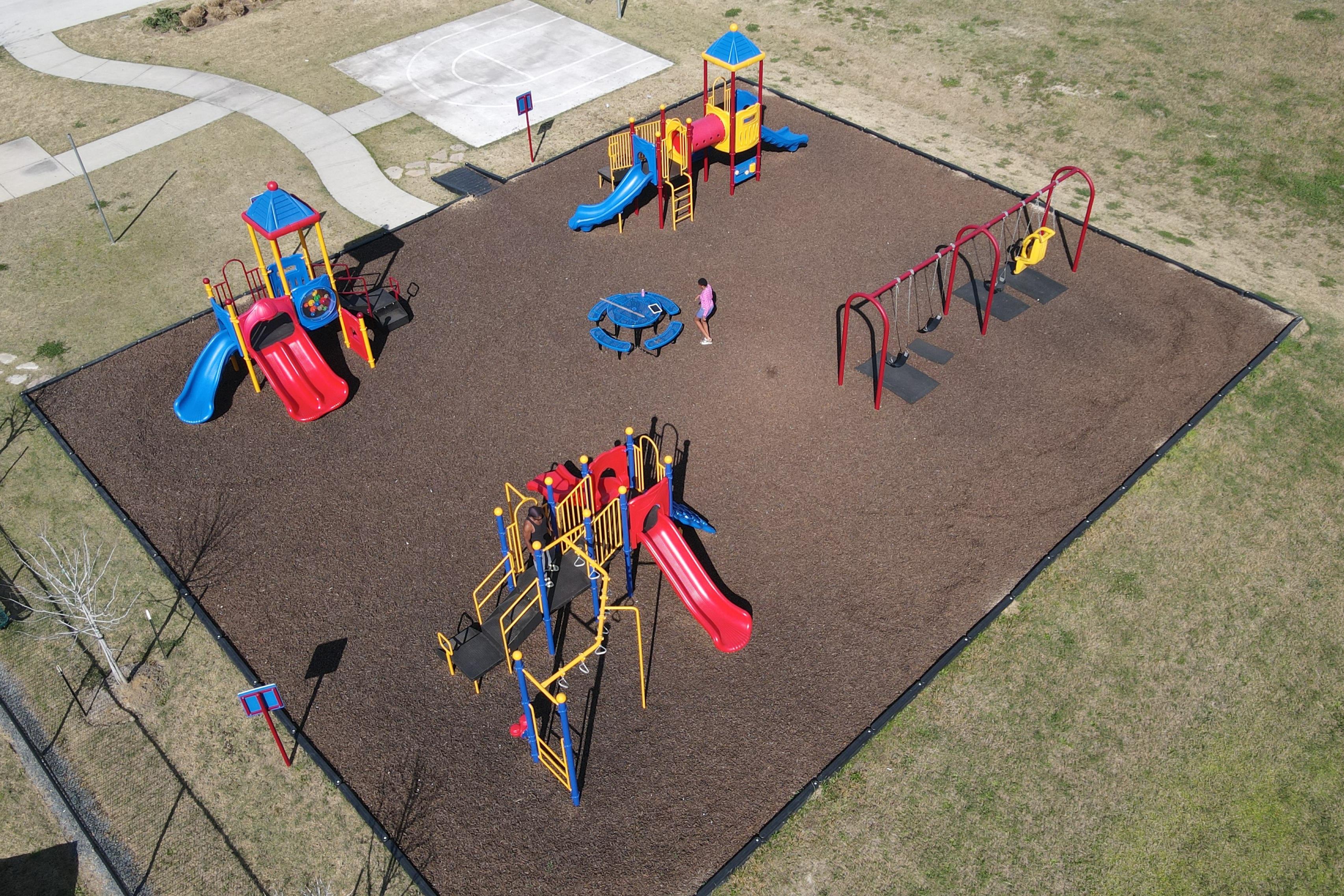 Colorful playground with slides, swings and play towers at The Villages at WestPointe in Dayton, Texas