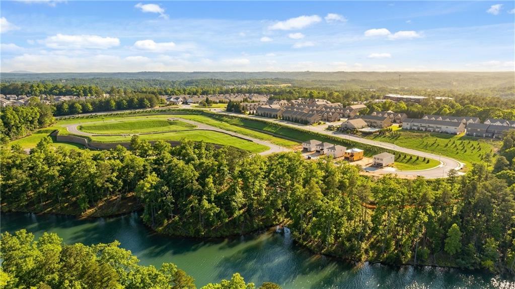 Aerial view of The Bluffs community in Canton, Georgia, showcasing Davidson Homes craftsman residences amid lush trees and scenic river