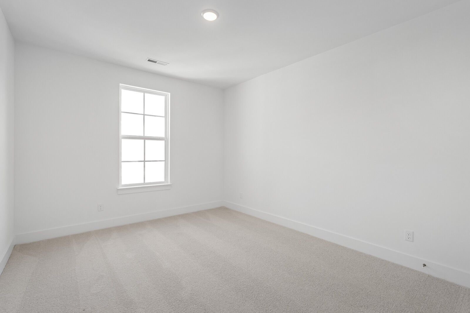 Empty bedroom featuring white walls, large window, beige carpet in 4-bedroom The Hawkins home by Davidson Homes, Murfreesboro, TN