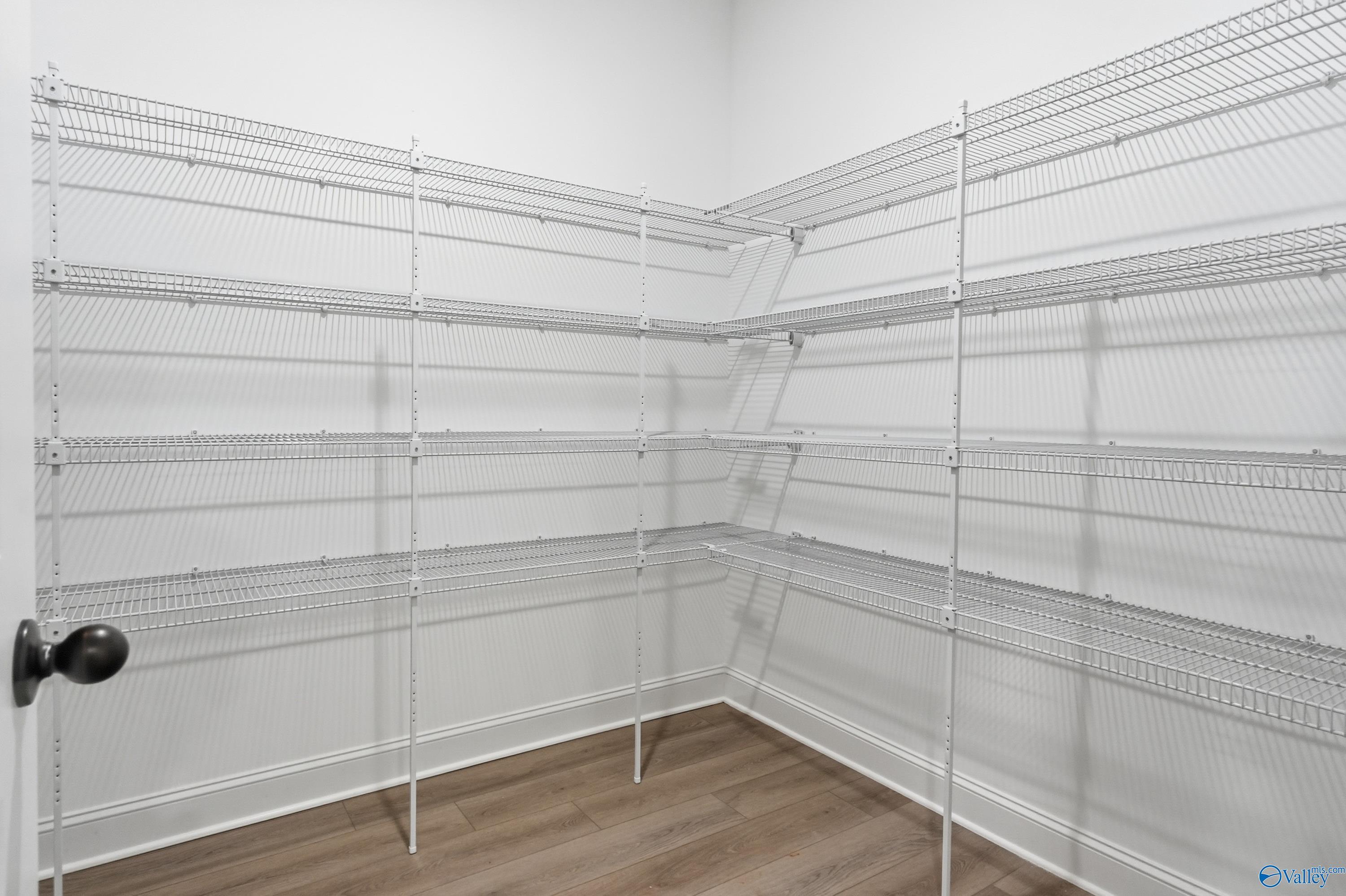 Spacious walk-in pantry with white wire shelving, hardwood floors in Davidson Homes The Finleigh, Meridianville, Alabama