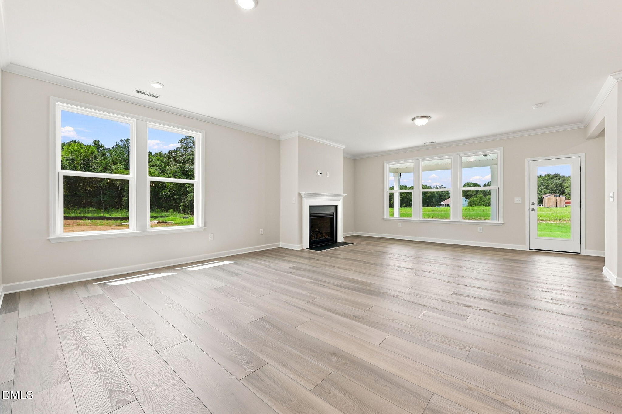 Spacious living room with fireplace and wood-look flooring in The Magnolia B floor plan at Retreat at North Main, Lillington.