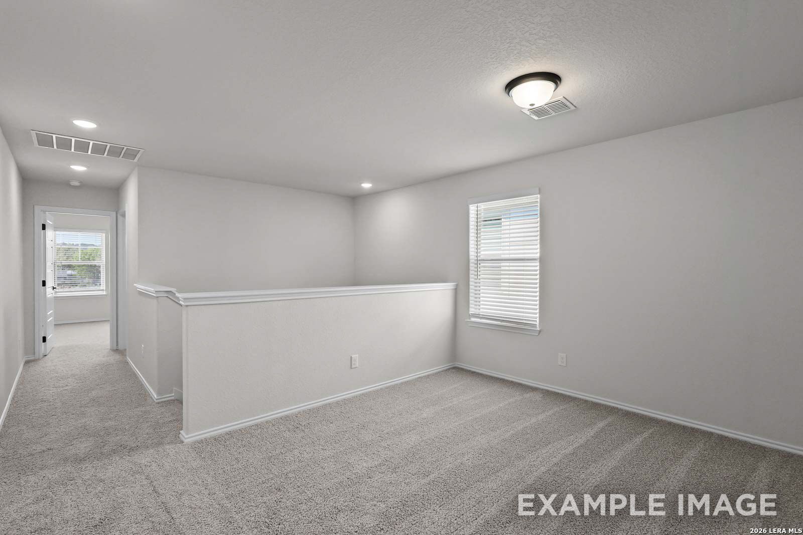Spacious upstairs loft area with neutral carpet in The Florence D floor plan by Davidson Homes in San Antonio, Texas.