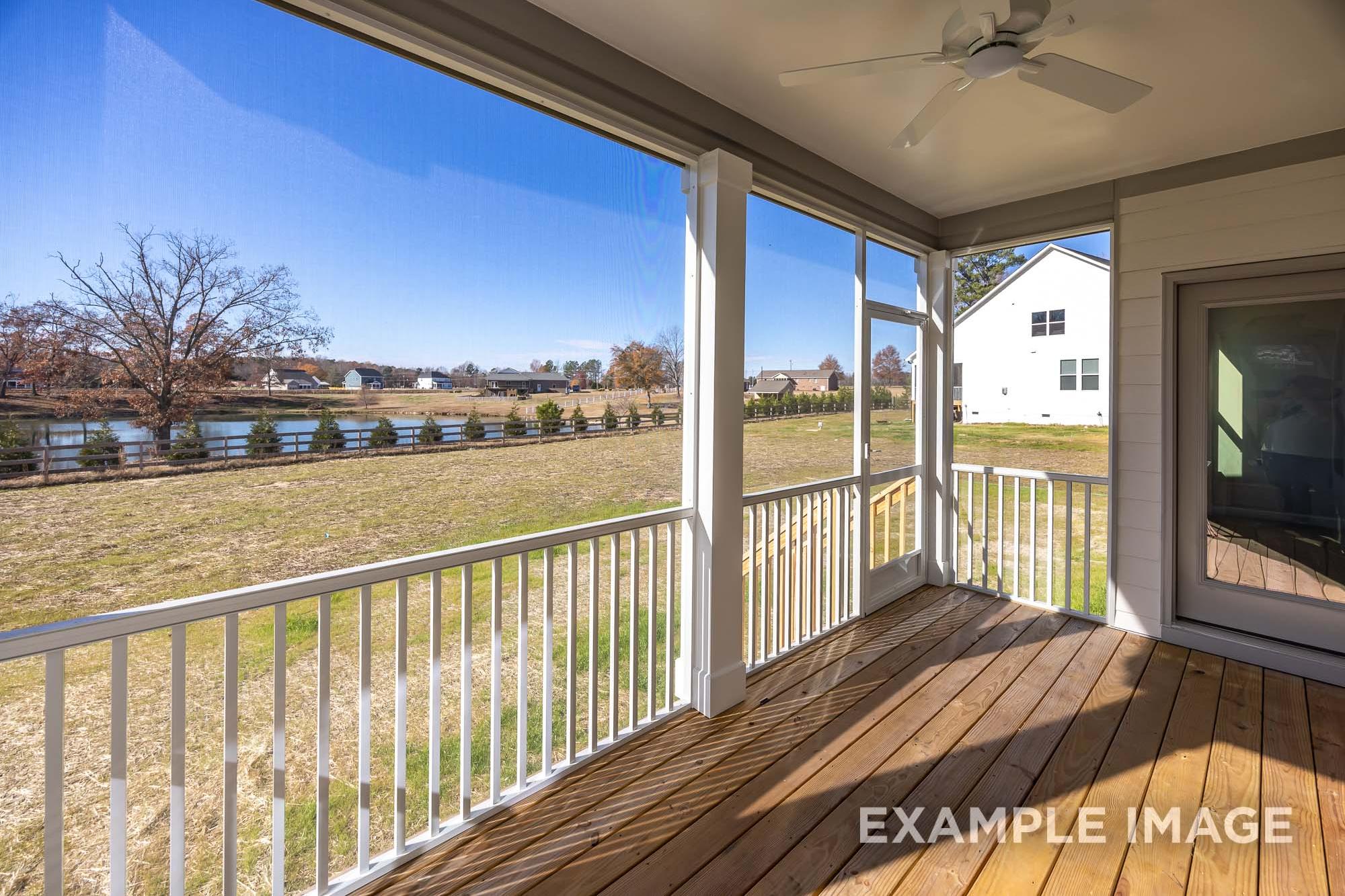 Screened porch of The Cypress C II Davidson Homes design with white railings, ceiling fan, and scenic field view