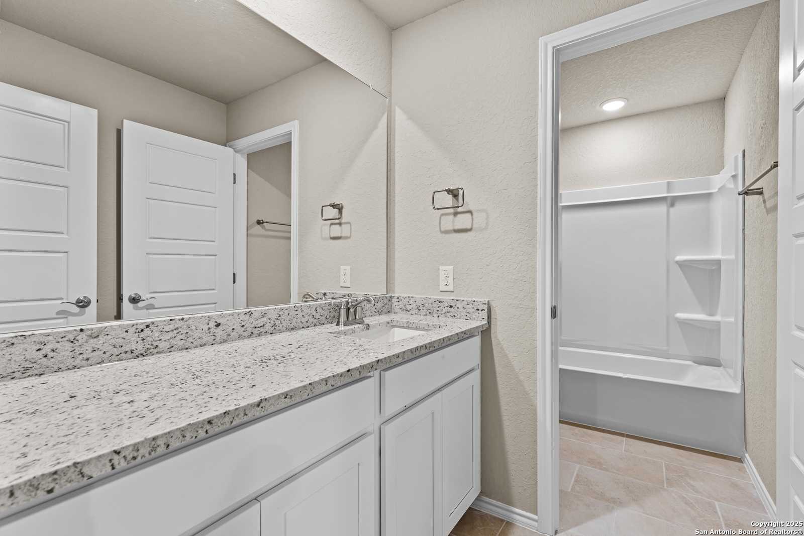 Modern master bathroom featuring double granite vanity, walk-in shower, soaking tub in Davidson Homes The Douglas F, San Antonio