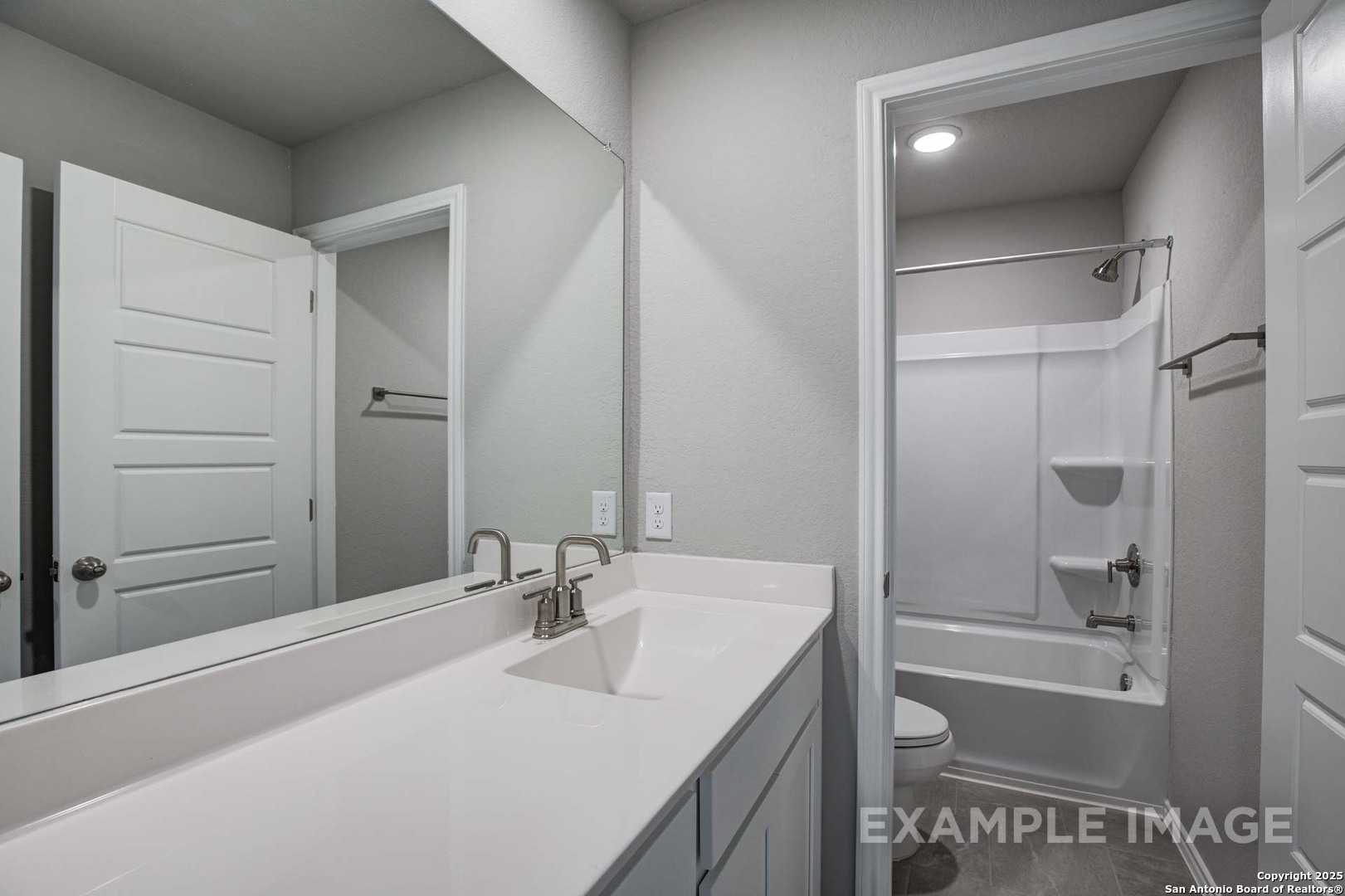 Elegant master bathroom with double white vanity, large mirror, and tub-shower combo in Davidson Homes The Blanco C, Agave, San Antonio