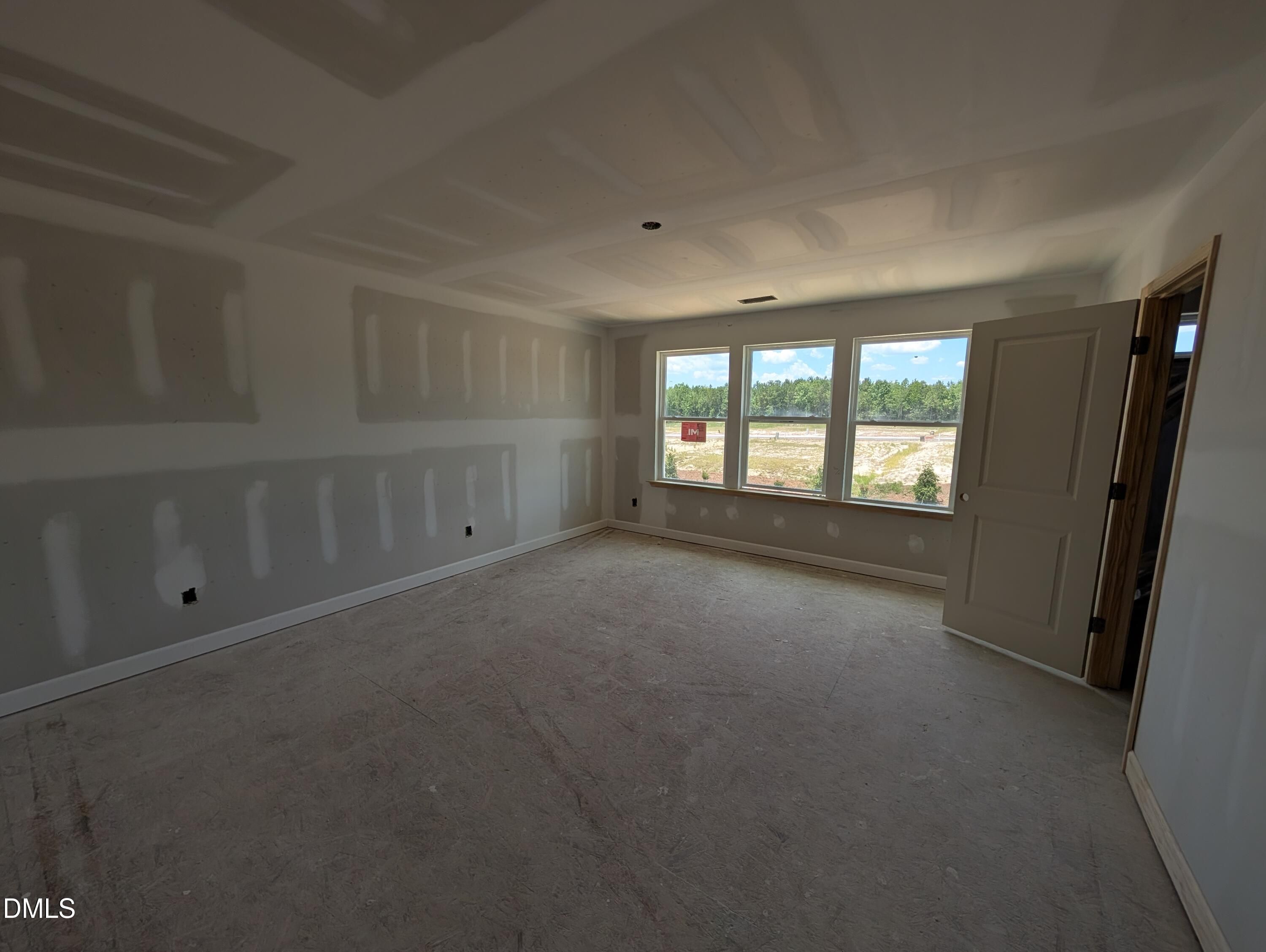 Unfinished spacious bedroom with drywall in The Chestnut floor plan at Wendell Ridge in Wendell, North Carolina.