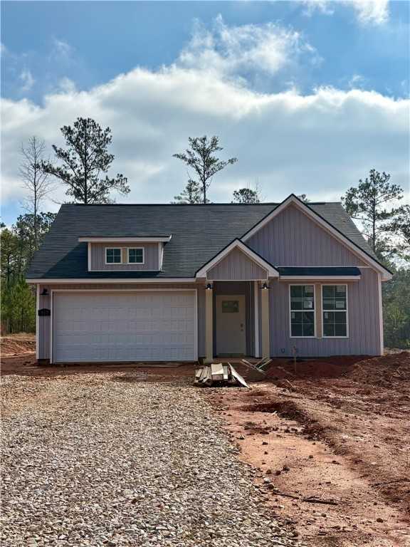 Modern 1-story 4-bedroom home with gray siding, 2-car garage, dormer window, and pine trees in Silver Oak, Cusseta, Alabama