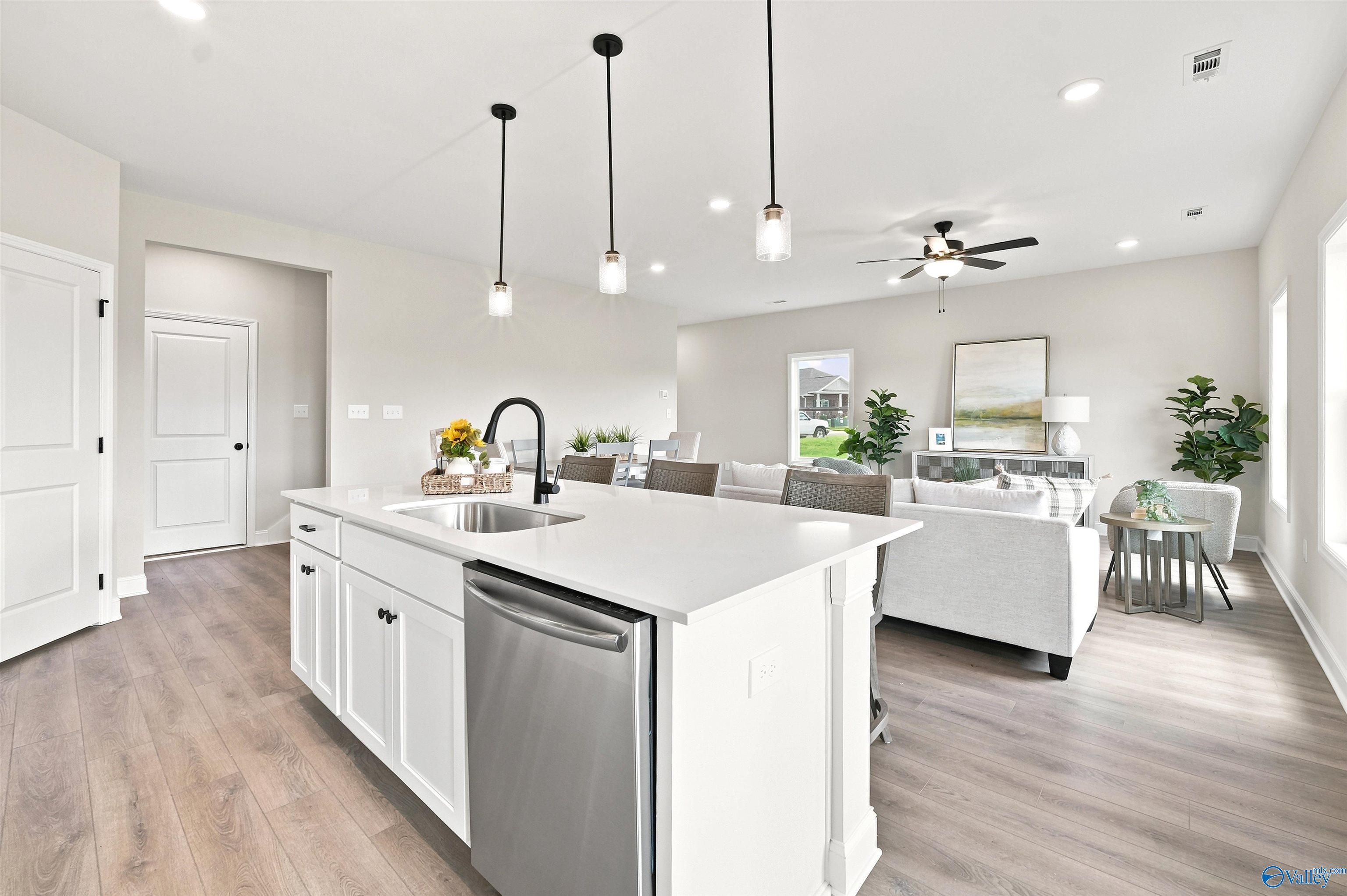 Open-concept kitchen with white island and pendant lighting in The Burton B floor plan at Heritage Lakes, New Market, AL.