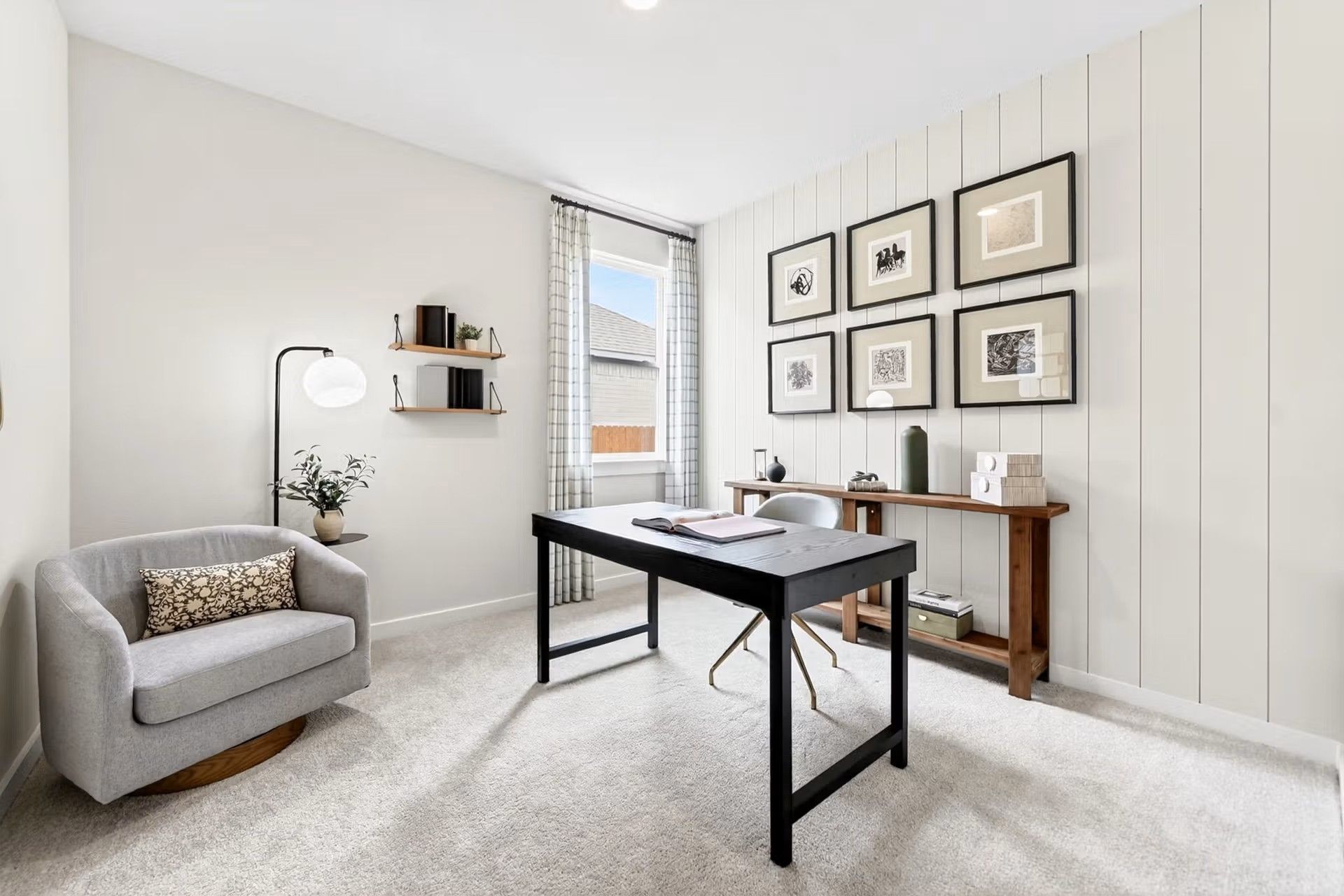 Modern home office with shiplap wall, black desk, and cozy armchair in The Laurel I floor plan by Davidson Homes in Heartland.
