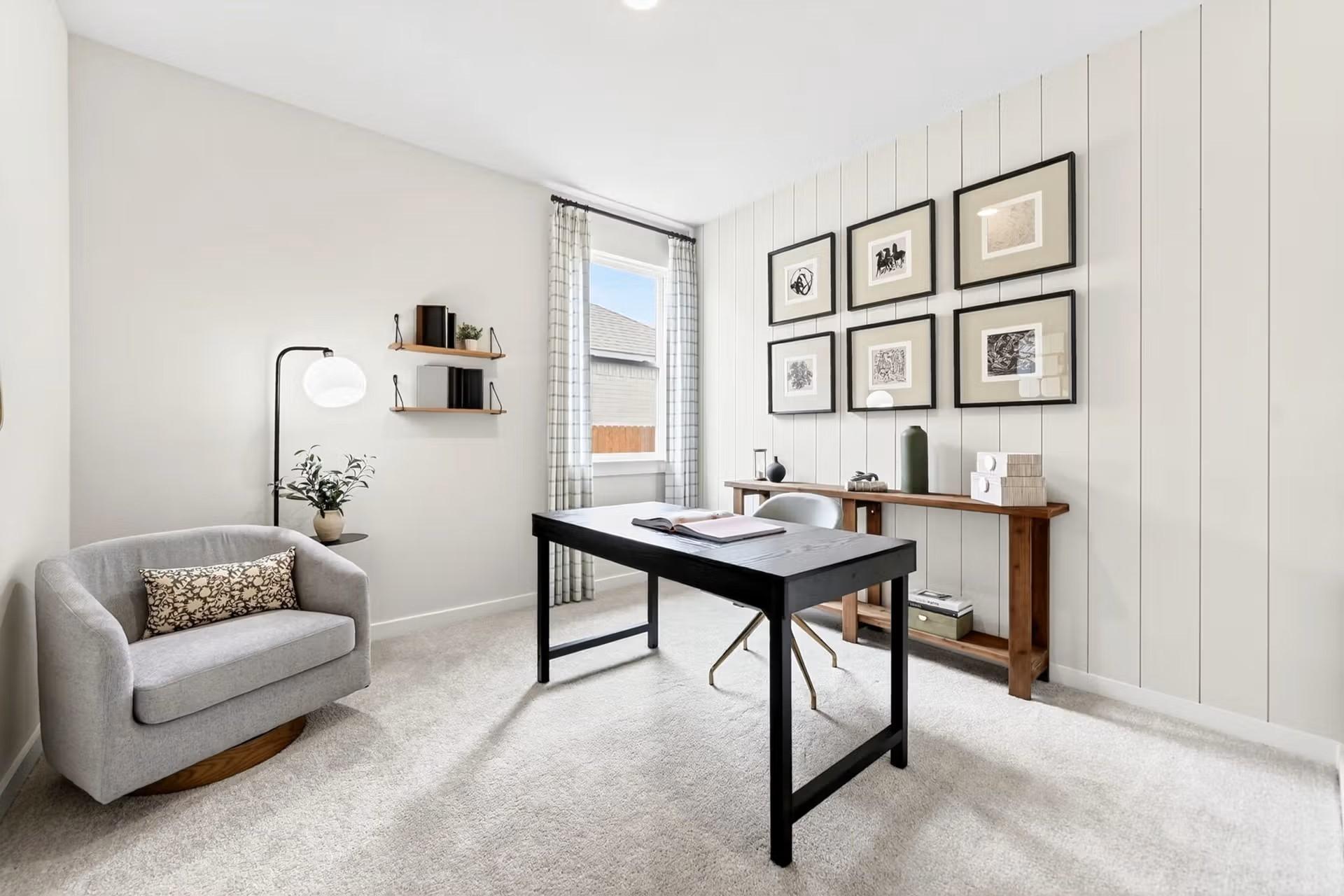 Modern home office with shiplap wall, black desk, and cozy armchair in The Laurel I floor plan by Davidson Homes in Heartland.