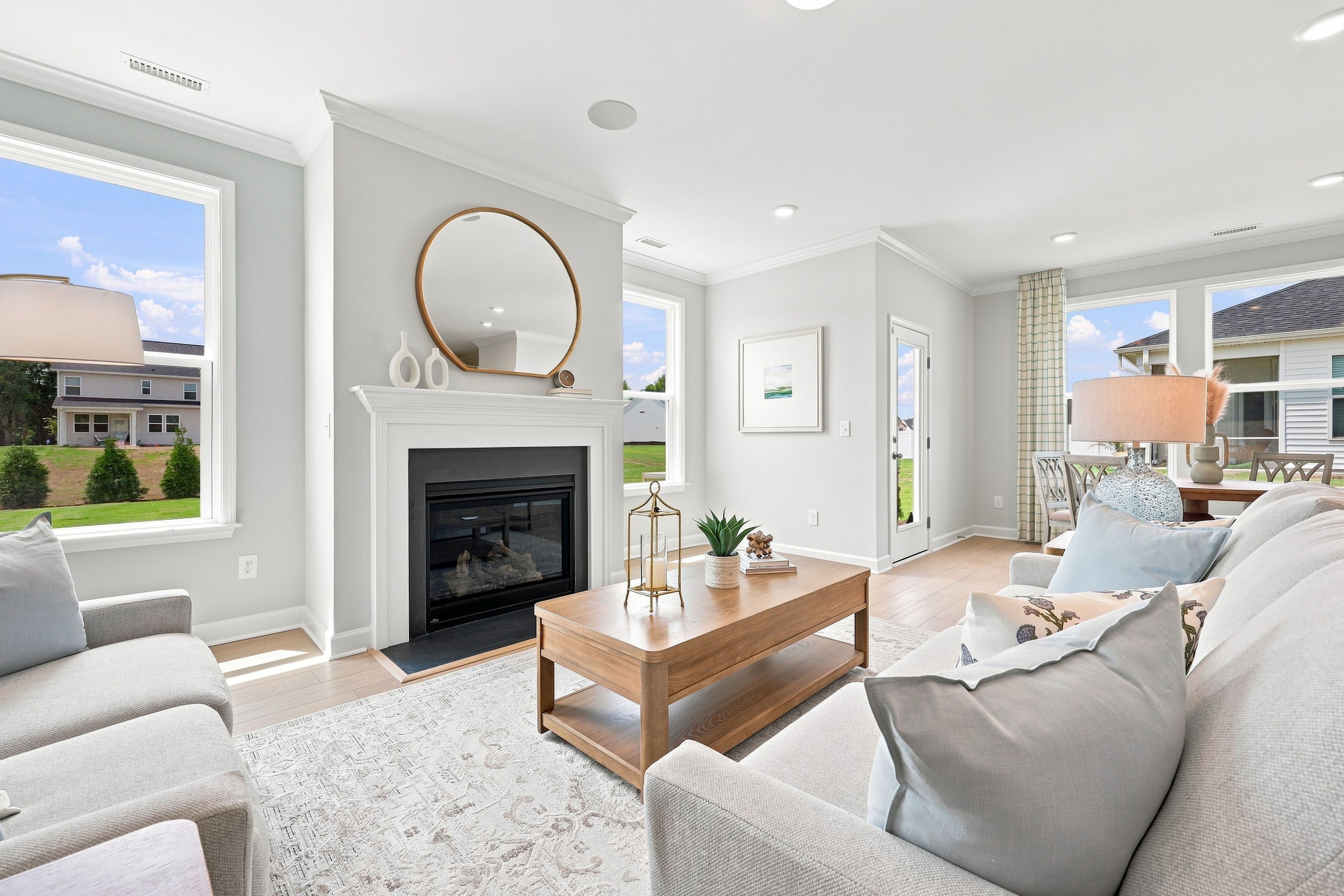 Bright open-concept living room in The Daphne D by Davidson Homes featuring a cozy fireplace and modern farmhouse decor.