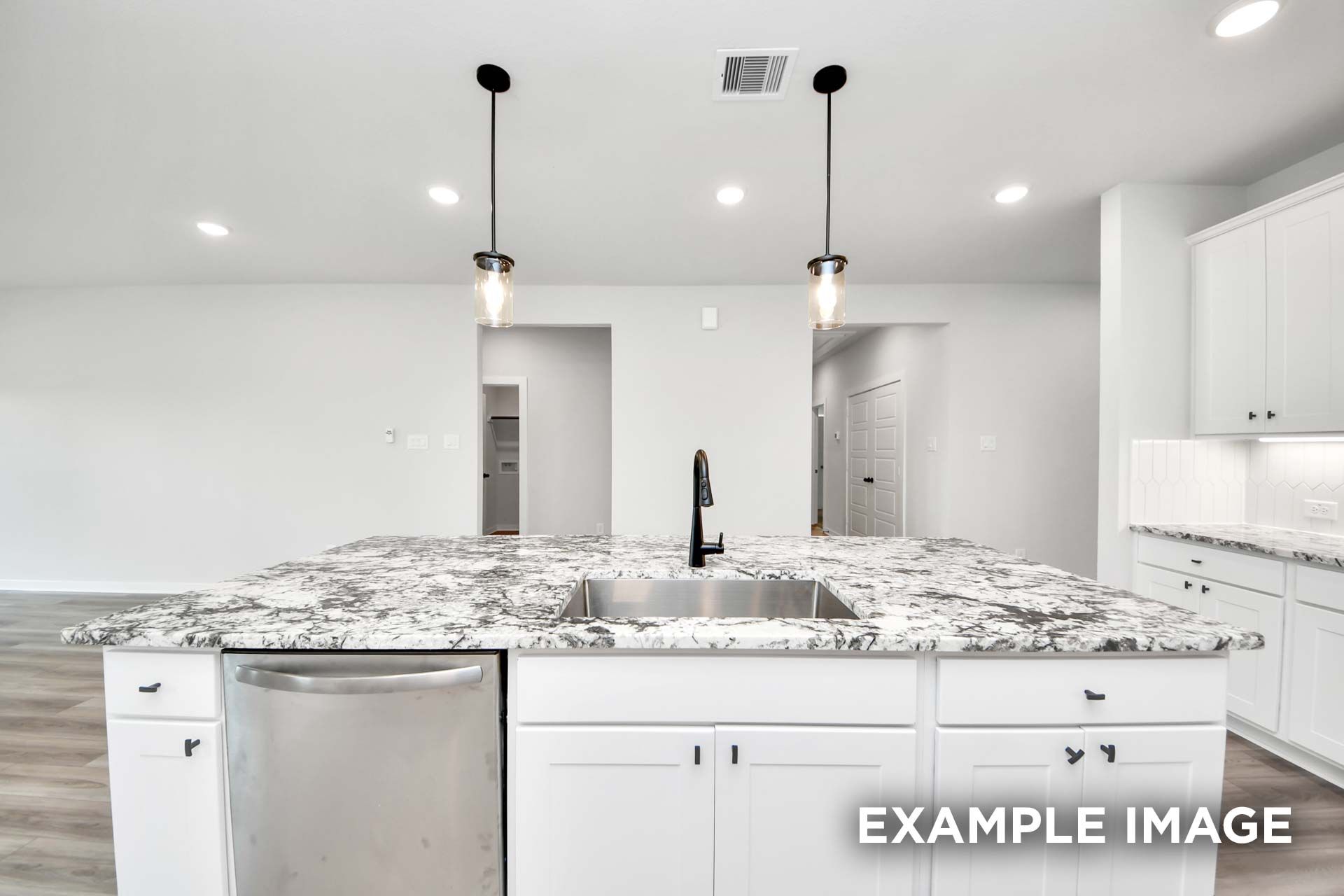 Modern kitchen island with granite countertop and pendant lighting in The Sorrento home design by Davidson Homes.