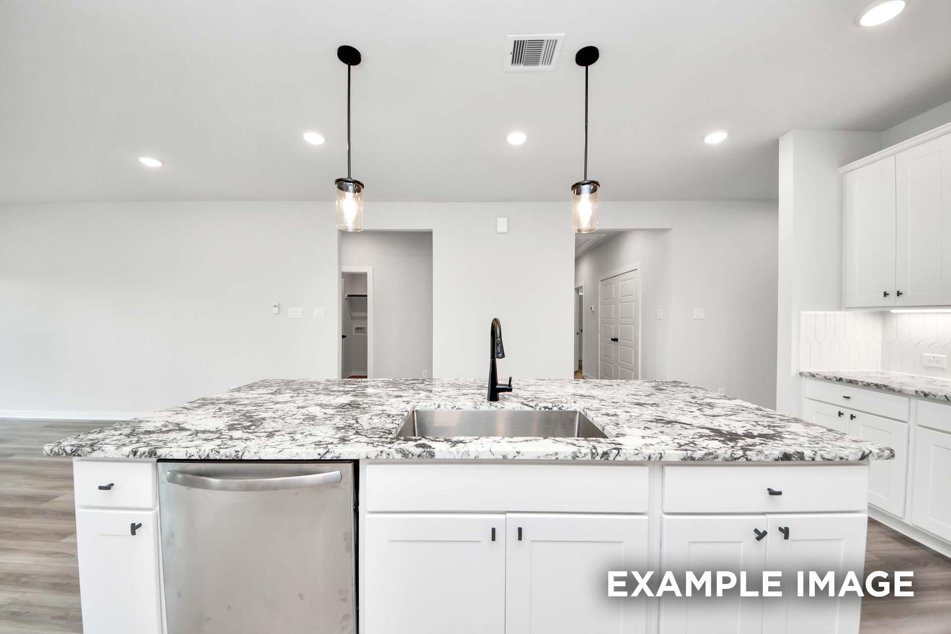 Modern kitchen island with granite countertop and pendant lighting in The Sorrento home design by Davidson Homes.