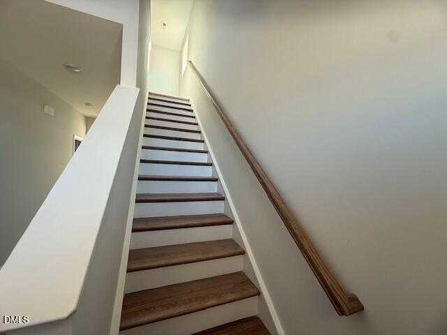 Elegant wooden staircase with white risers and handrail in 2-story The Gavin B home by Davidson Homes, Gregory Village, Lillington, NC
