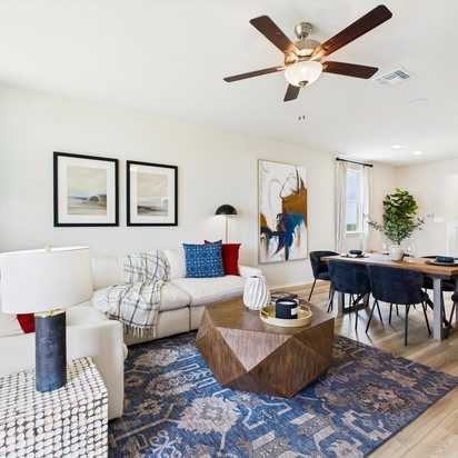 Modern kitchen in Agave San Antonio home by Davidson Homes featuring dark cabinets, granite island, stainless appliances and bar seating
