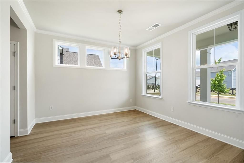 Bright dining room with chandelier, large windows, hardwood floors in Davidson Homes The Willow B, Hoschton, Georgia