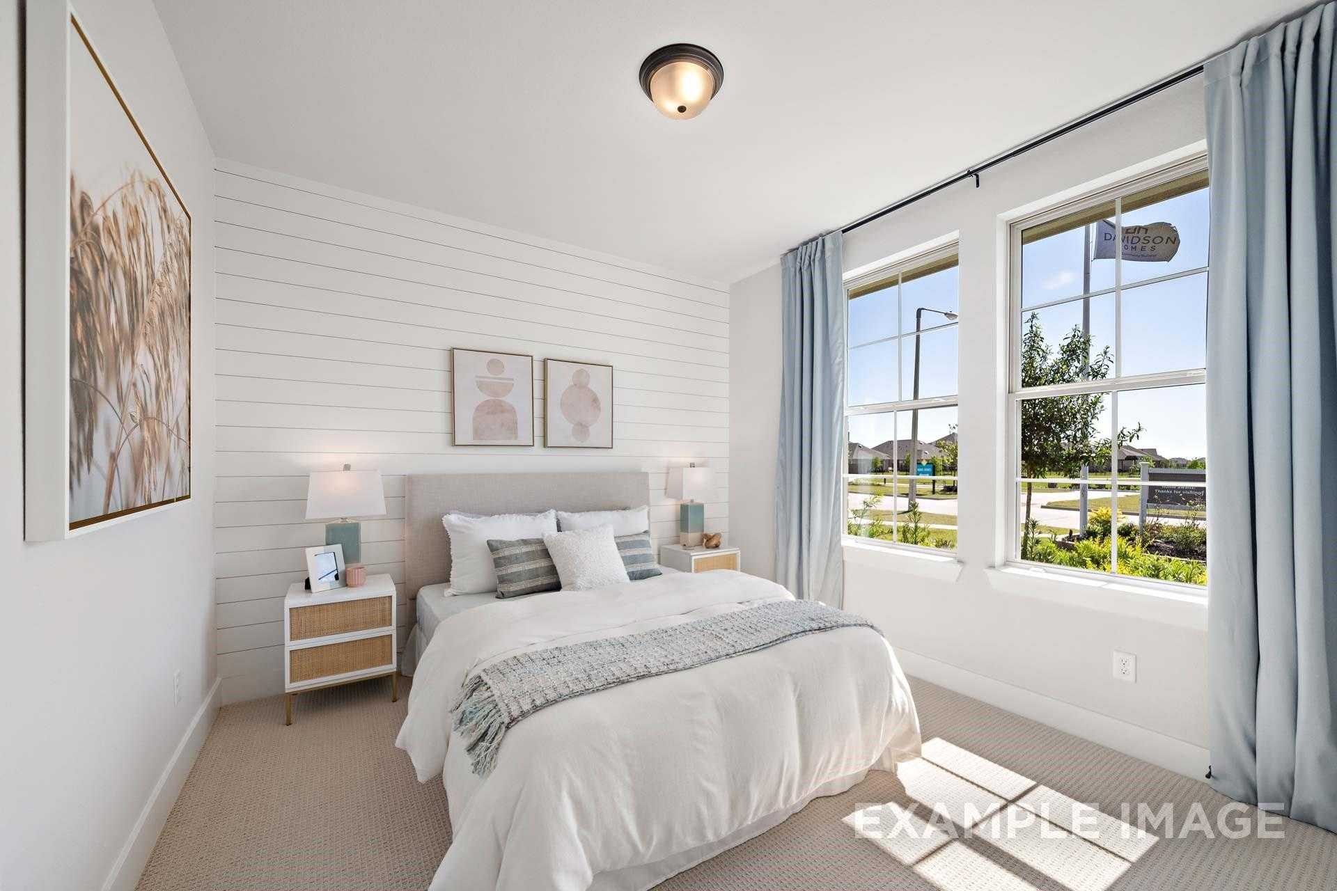 Cozy bedroom with shiplap walls, neutral bedding, large windows, and blue curtains in Davidson Homes The Edward A, Lago Mar, Texas City