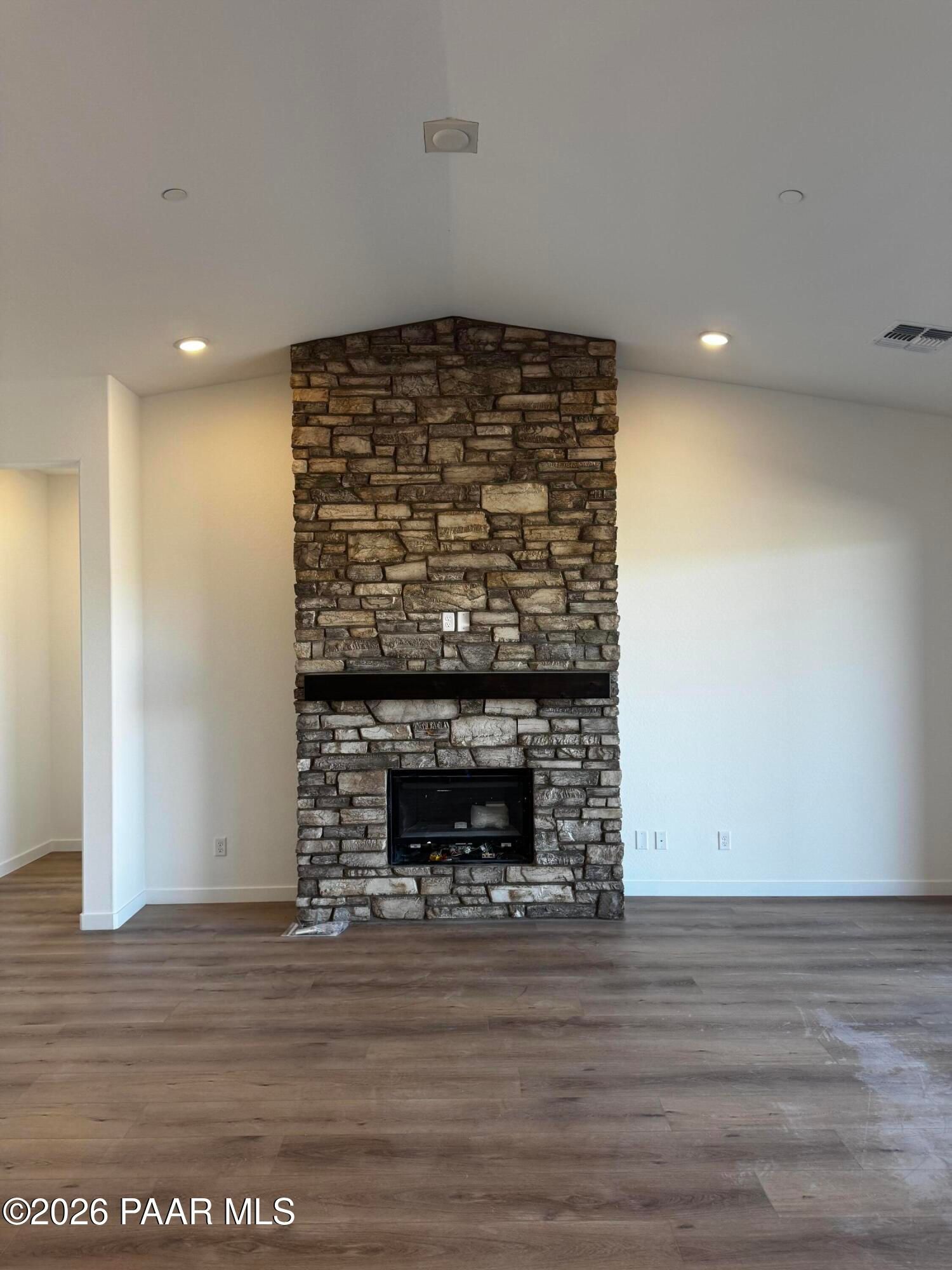 Impressive stone gas fireplace with mantel in open living room of 3-bedroom Davidson Homes The Blaze C, Hidden Hills, Prescott, Arizona