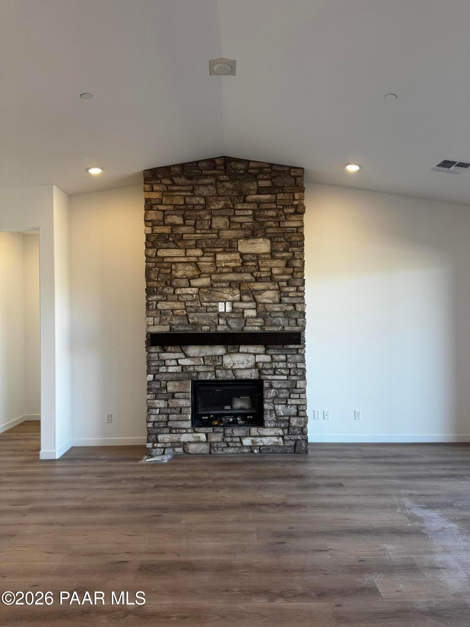 Impressive stone gas fireplace with mantel in open living room of 3-bedroom Davidson Homes The Blaze C, Hidden Hills, Prescott, Arizona