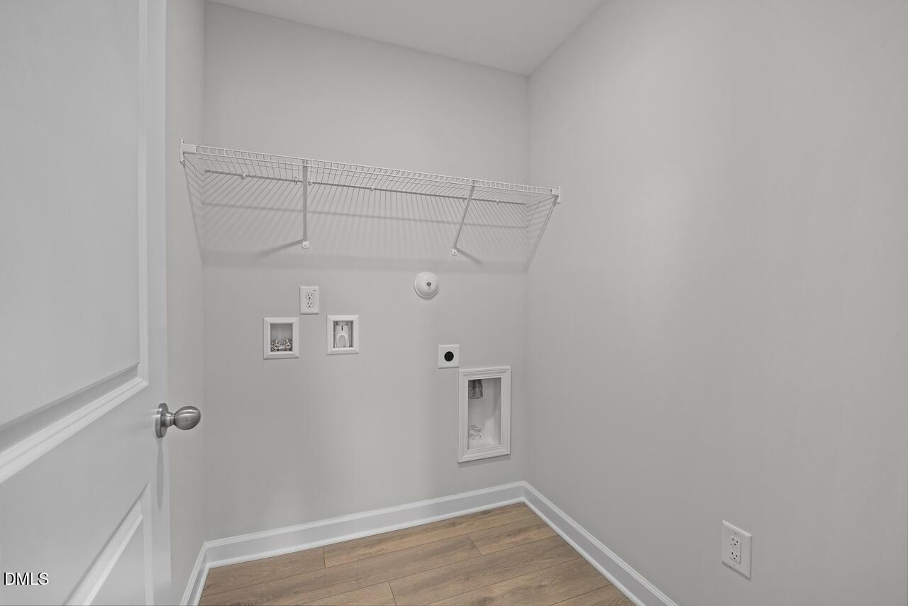 Laundry room with wire shelving and utility hookups in The Grace C floor plan at Retreat at North Main, Lillington, NC.