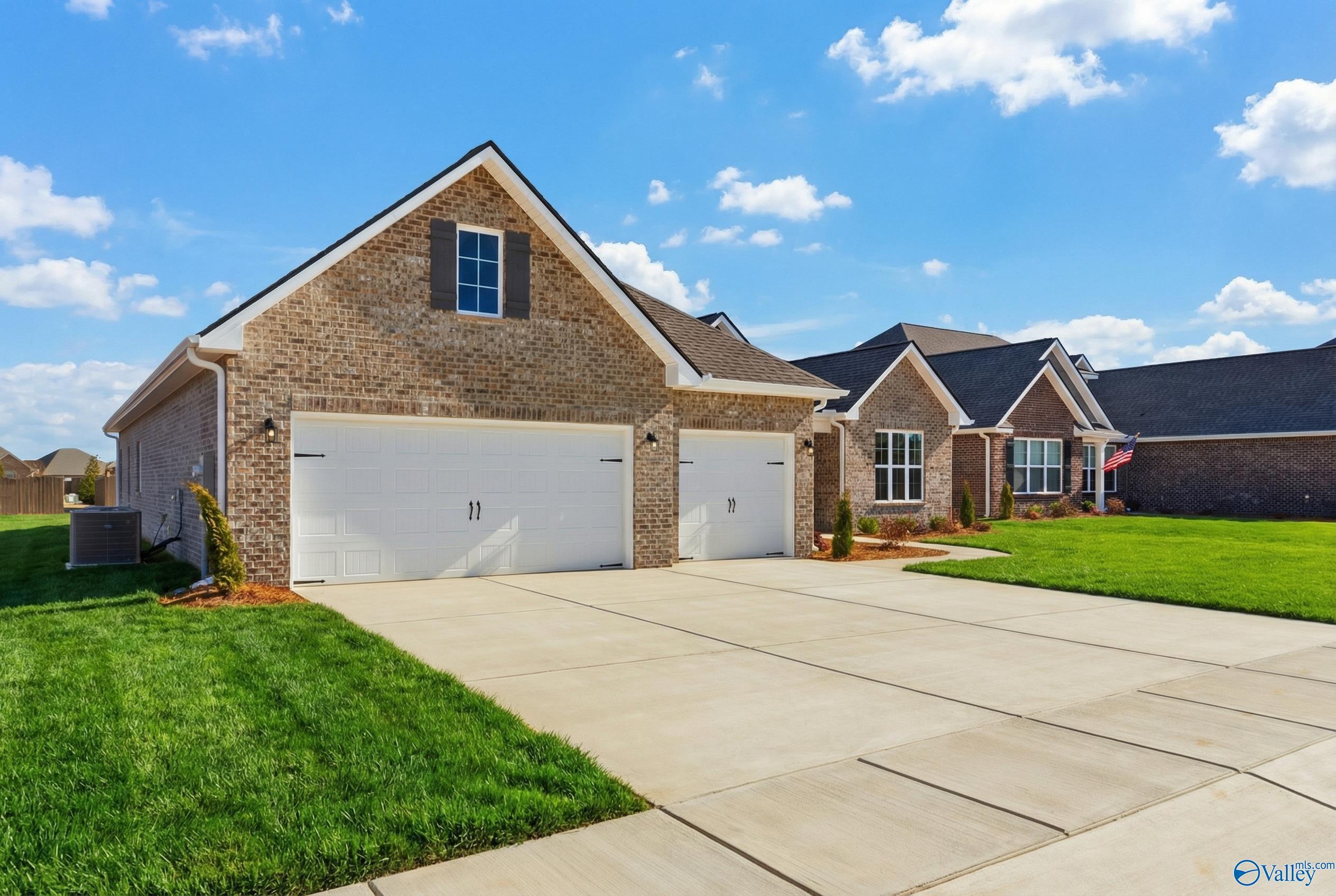 Brick 1-story The Finleigh home with 2-car garage, driveway, and lush lawn in Briercreek, Meridianville, Alabama