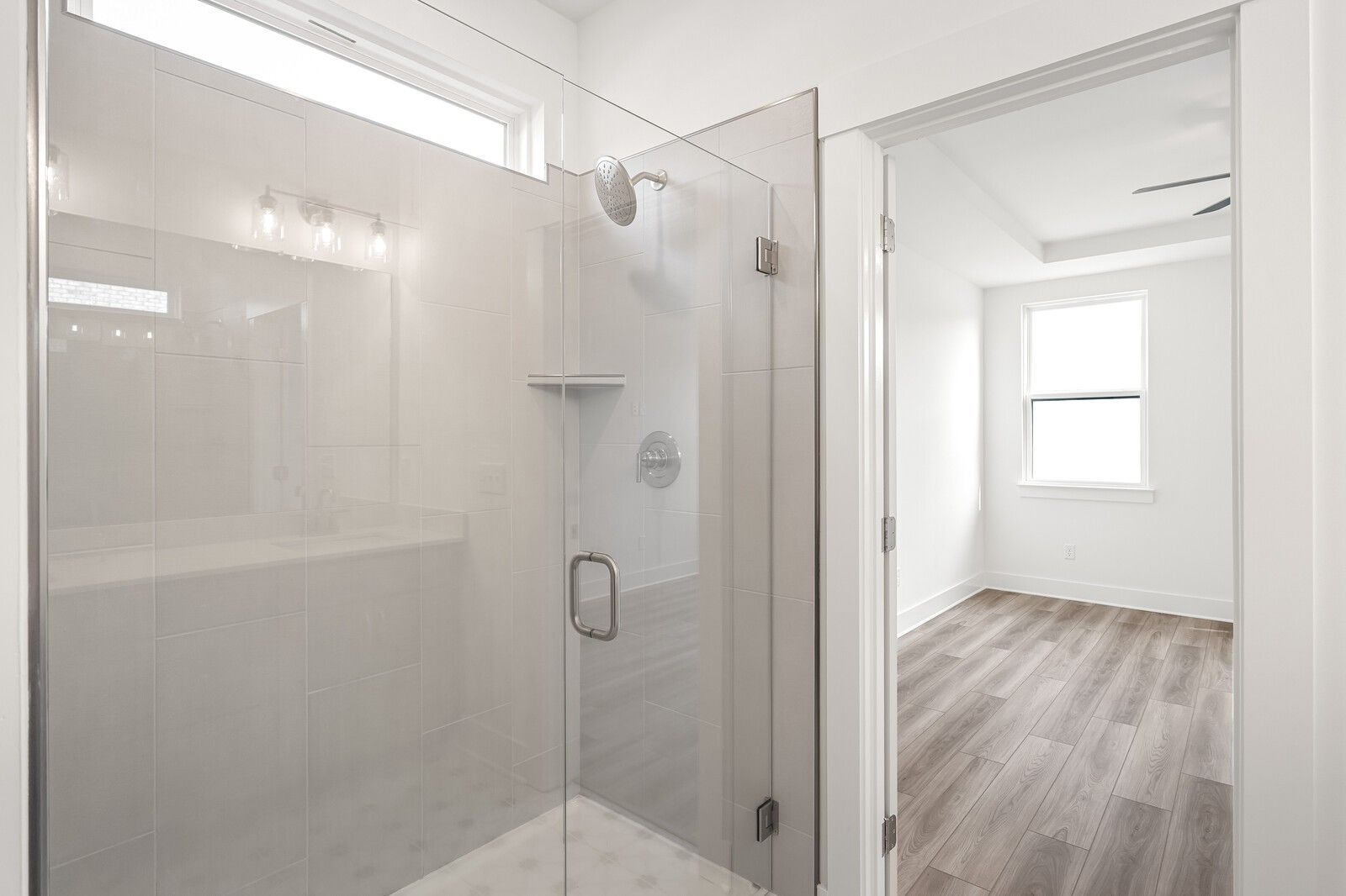 Modern frameless glass shower with rain head, white subway tiles, and niche in master bath of Davidson Homes The Ash C, Mt. Juliet, TN