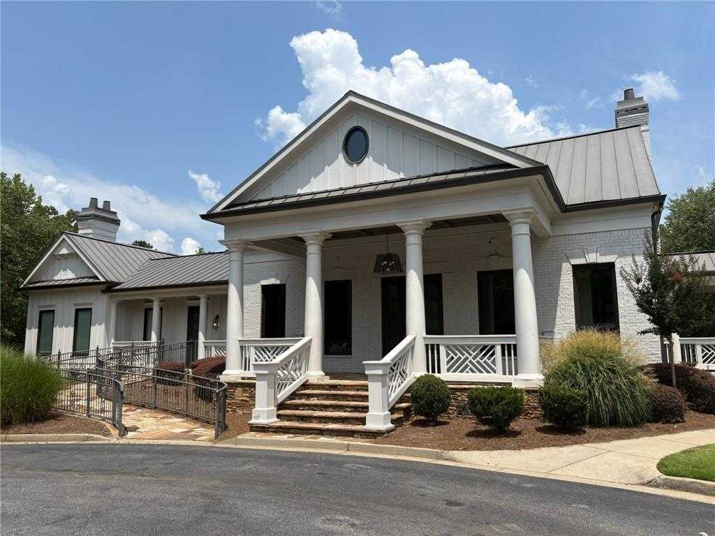Elegant two-story Davidson Homes exterior with columned porch, metal roof, and lush landscaping in Riverwood, Dallas, Georgia