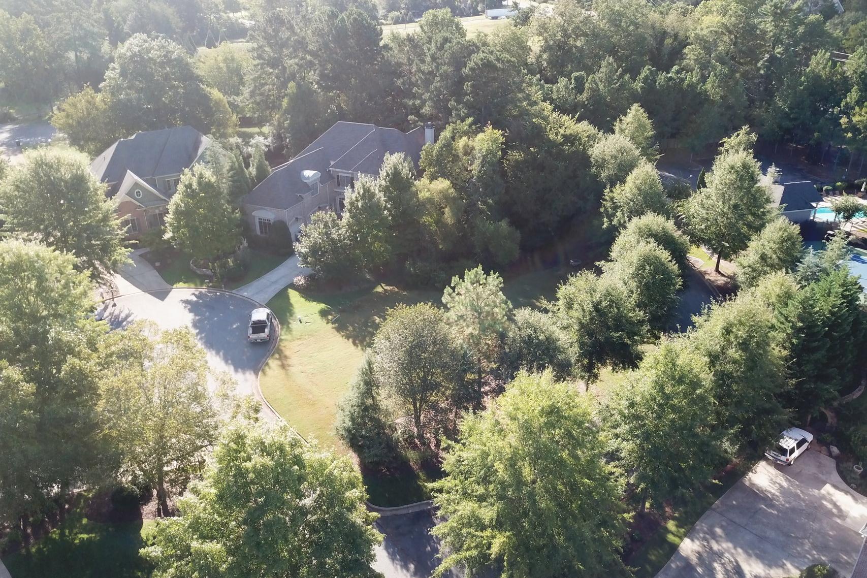 Aerial view of Tanglewood neighborhood in East Cobb Georgia with wooded Davidson Homes lots driveways and community pool